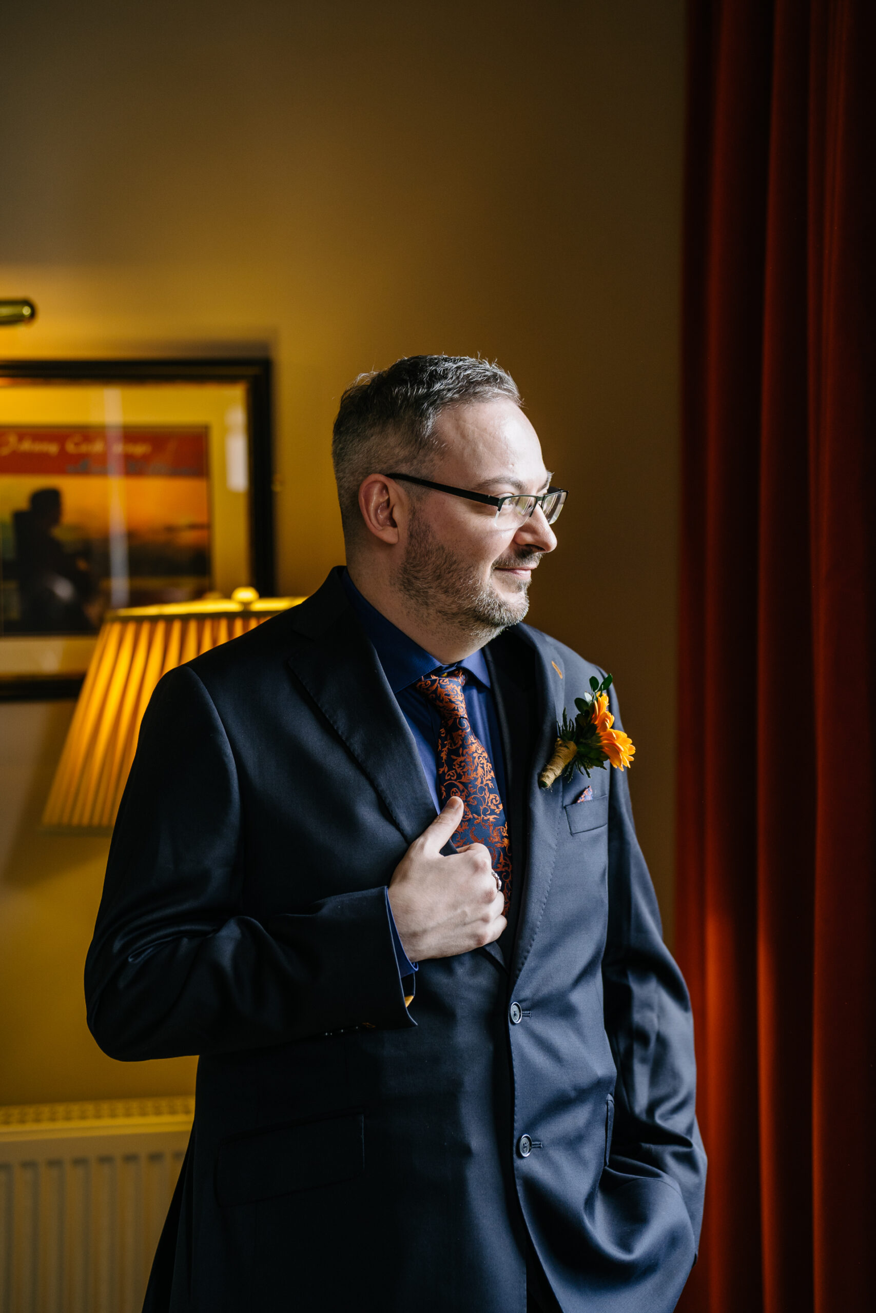 Two grooms preparing for their LGBT wedding in the bridal suite at Markree Castle, featuring elegant wedding details." "A groom adjusting his tie in the luxurious suite of Markree Castle." "Wedding details, including cufflinks and shoes, during the preparation of two grooms at Markree Castle