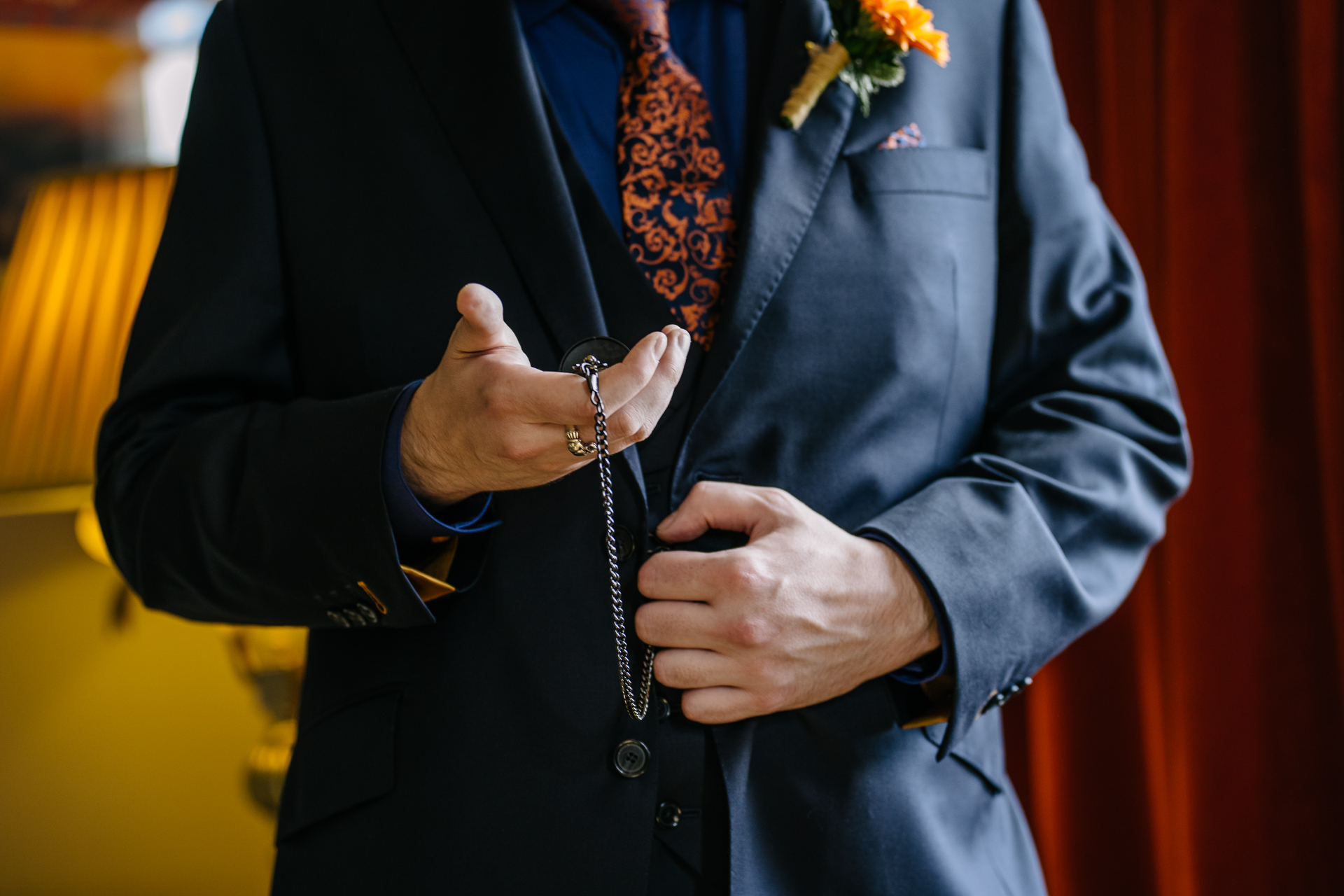 Two grooms preparing for their LGBT wedding in the bridal suite at Markree Castle, featuring elegant wedding details." "A groom adjusting his tie in the luxurious suite of Markree Castle." "Wedding details, including cufflinks and shoes, during the preparation of two grooms at Markree Castle