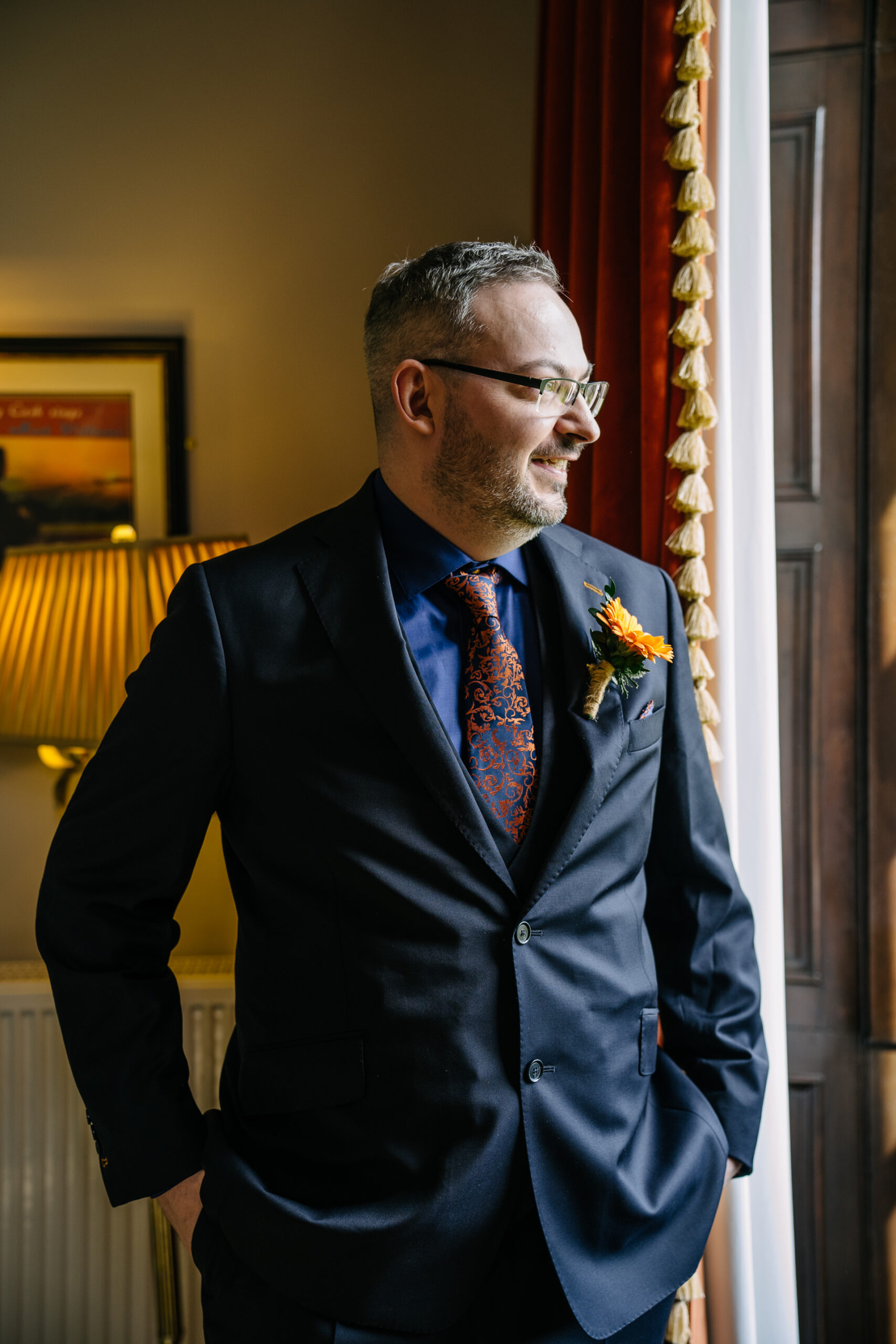 Two grooms preparing for their LGBT wedding in the bridal suite at Markree Castle, featuring elegant wedding details." "A groom adjusting his tie in the luxurious suite of Markree Castle." "Wedding details, including cufflinks and shoes, during the preparation of two grooms at Markree Castle