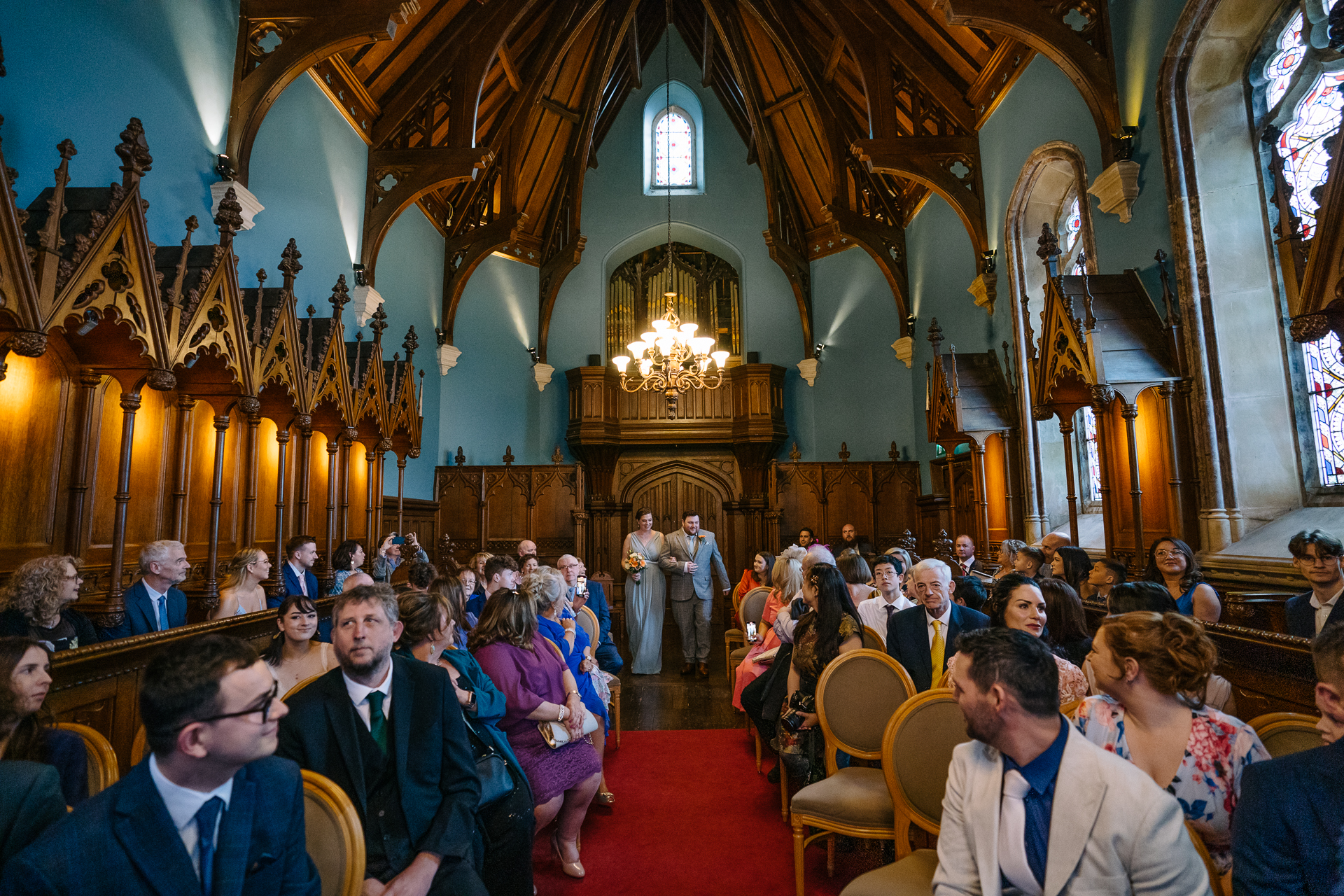 Two grooms exchanging vows during their LGBT wedding ceremony in the chapel of Markree Castle"A groom adjusting his tie in the luxurious suite of Markree Castle." "Wedding details, including cufflinks and shoes, during the preparation of two grooms at Markree Castle