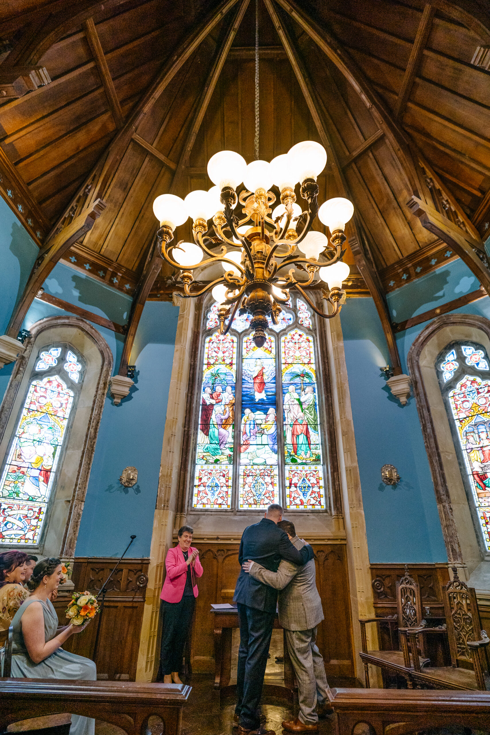 Two grooms exchanging vows during their LGBT wedding ceremony in the chapel of Markree Castle"A groom adjusting his tie in the luxurious suite of Markree Castle." "Wedding details, including cufflinks and shoes, during the preparation of two grooms at Markree Castle