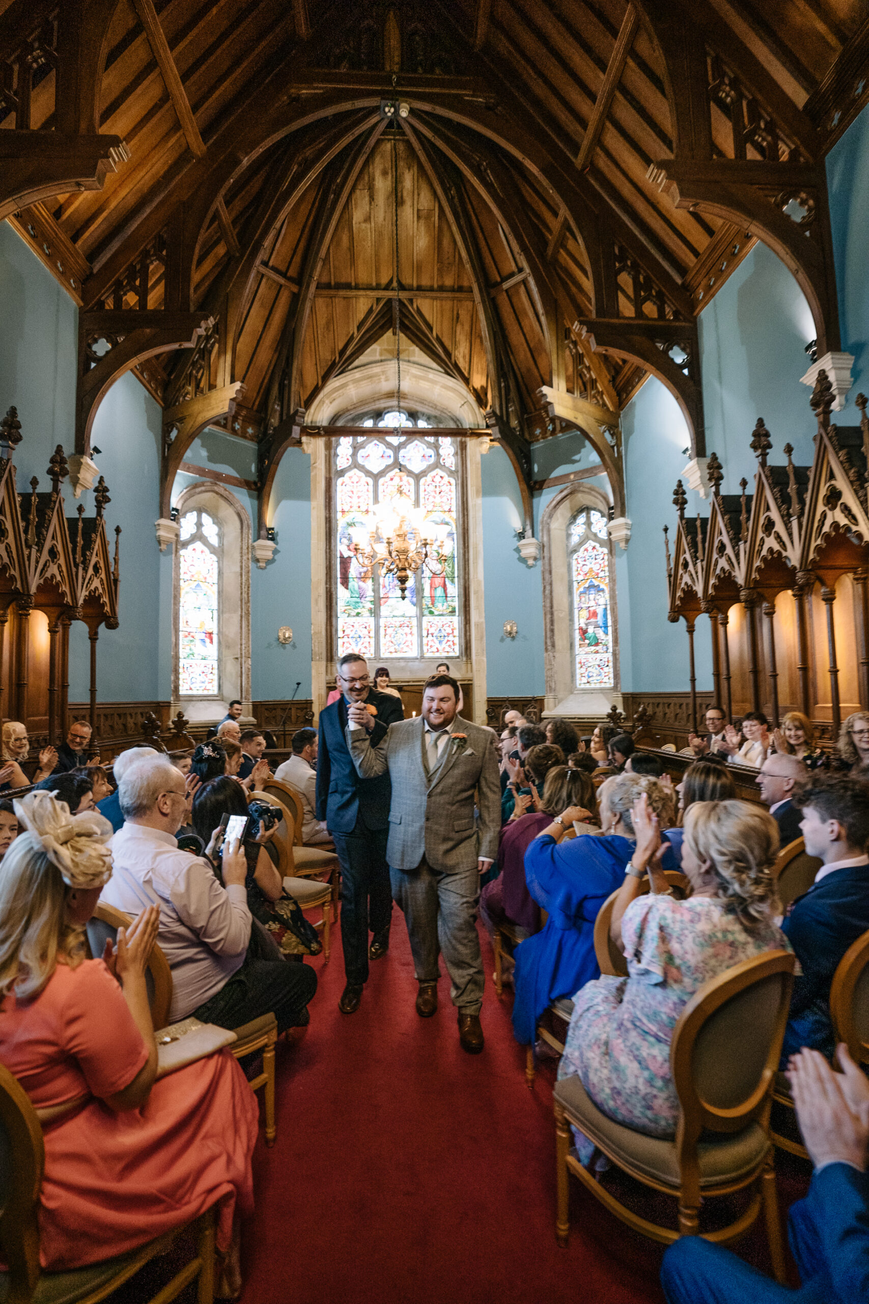 Two grooms exchanging vows during their LGBT wedding ceremony in the chapel of Markree Castle"A groom adjusting his tie in the luxurious suite of Markree Castle." "Wedding details, including cufflinks and shoes, during the preparation of two grooms at Markree Castle