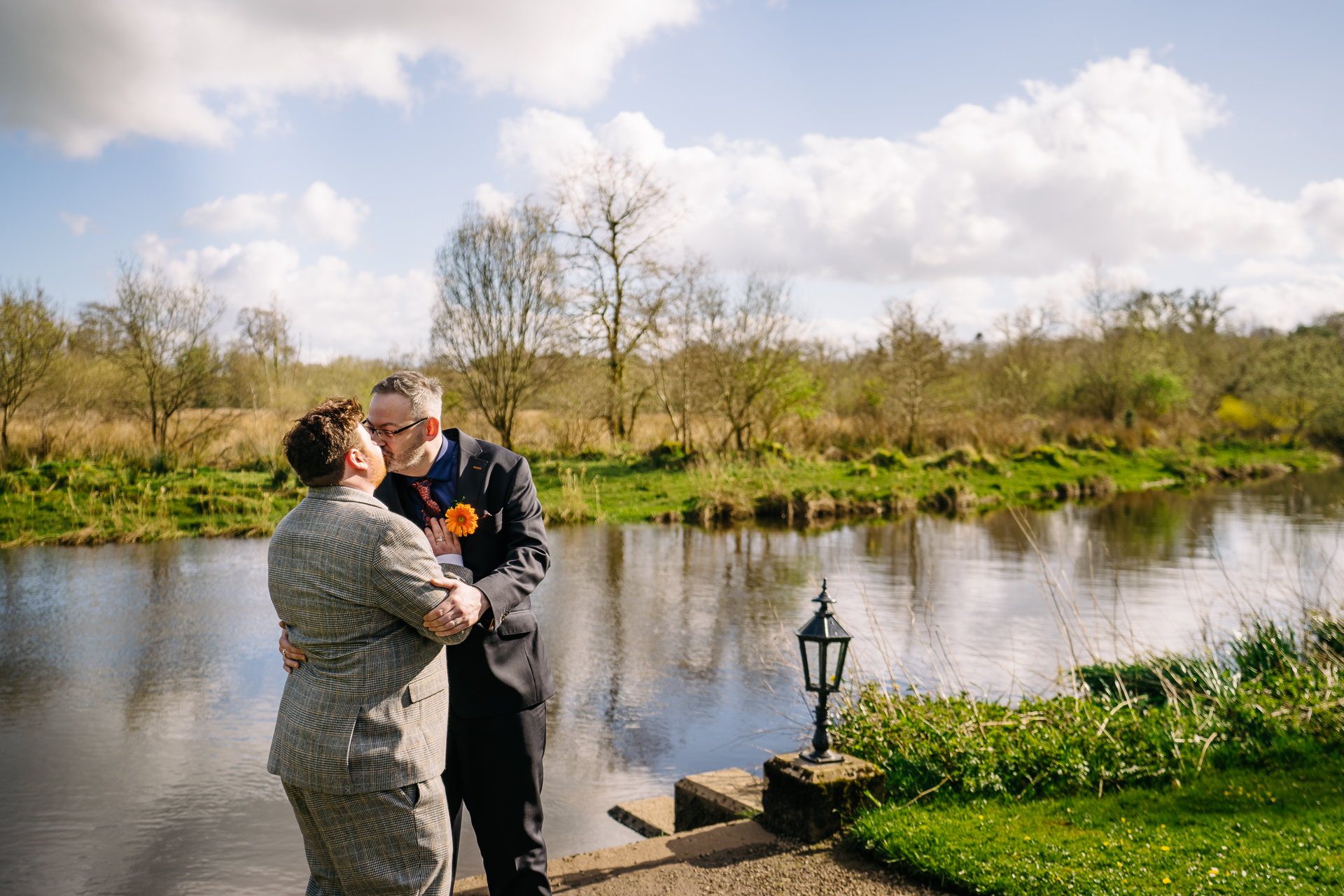 A man and woman kissing by a river