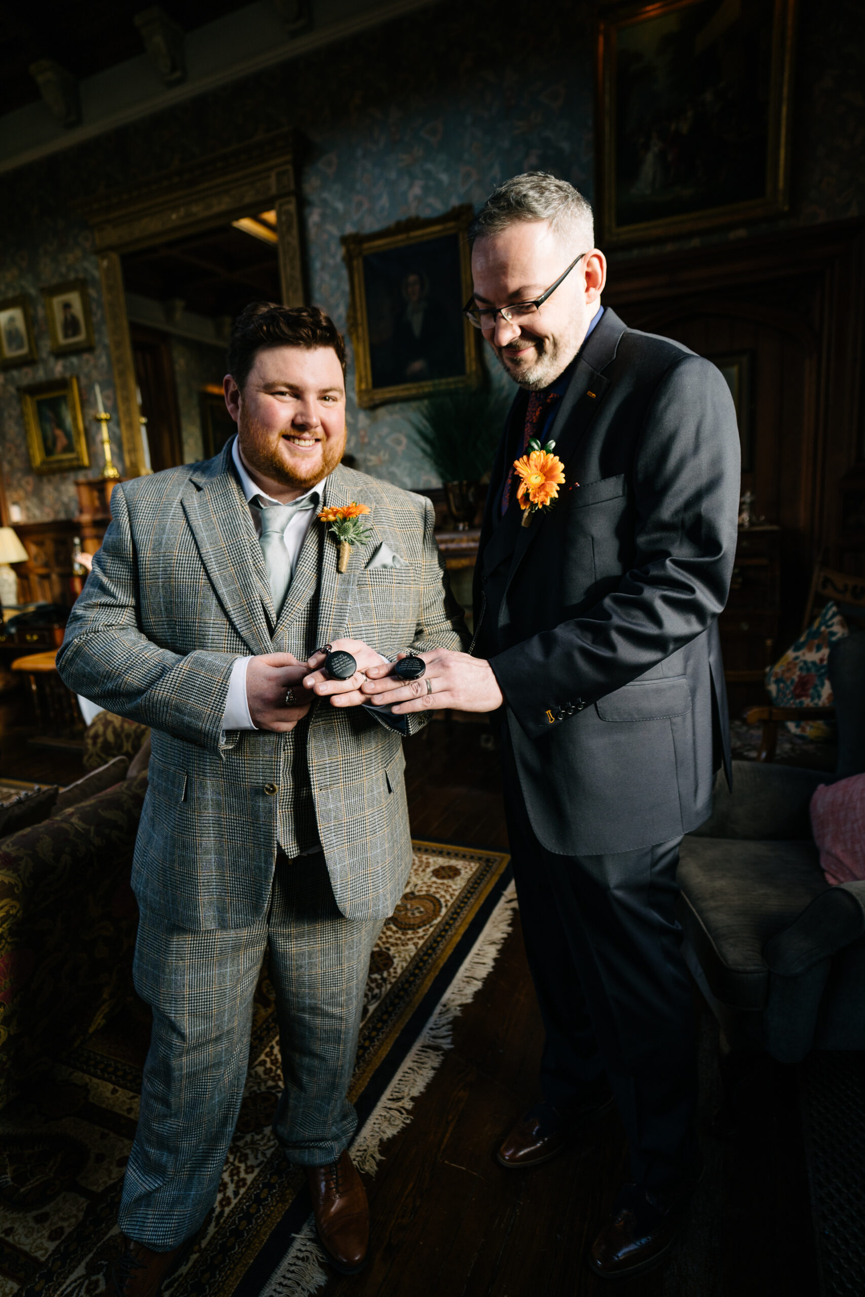 A man holding a phone next to a man holding a flower