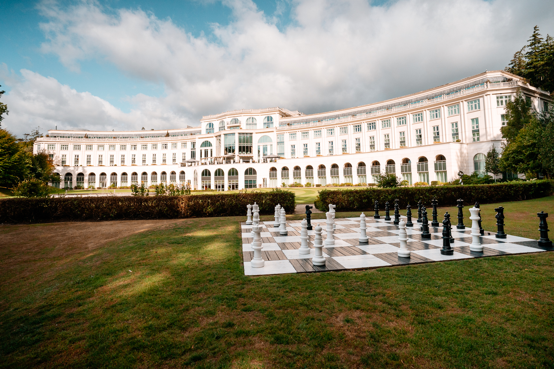 A large white building with a fountain in front of it