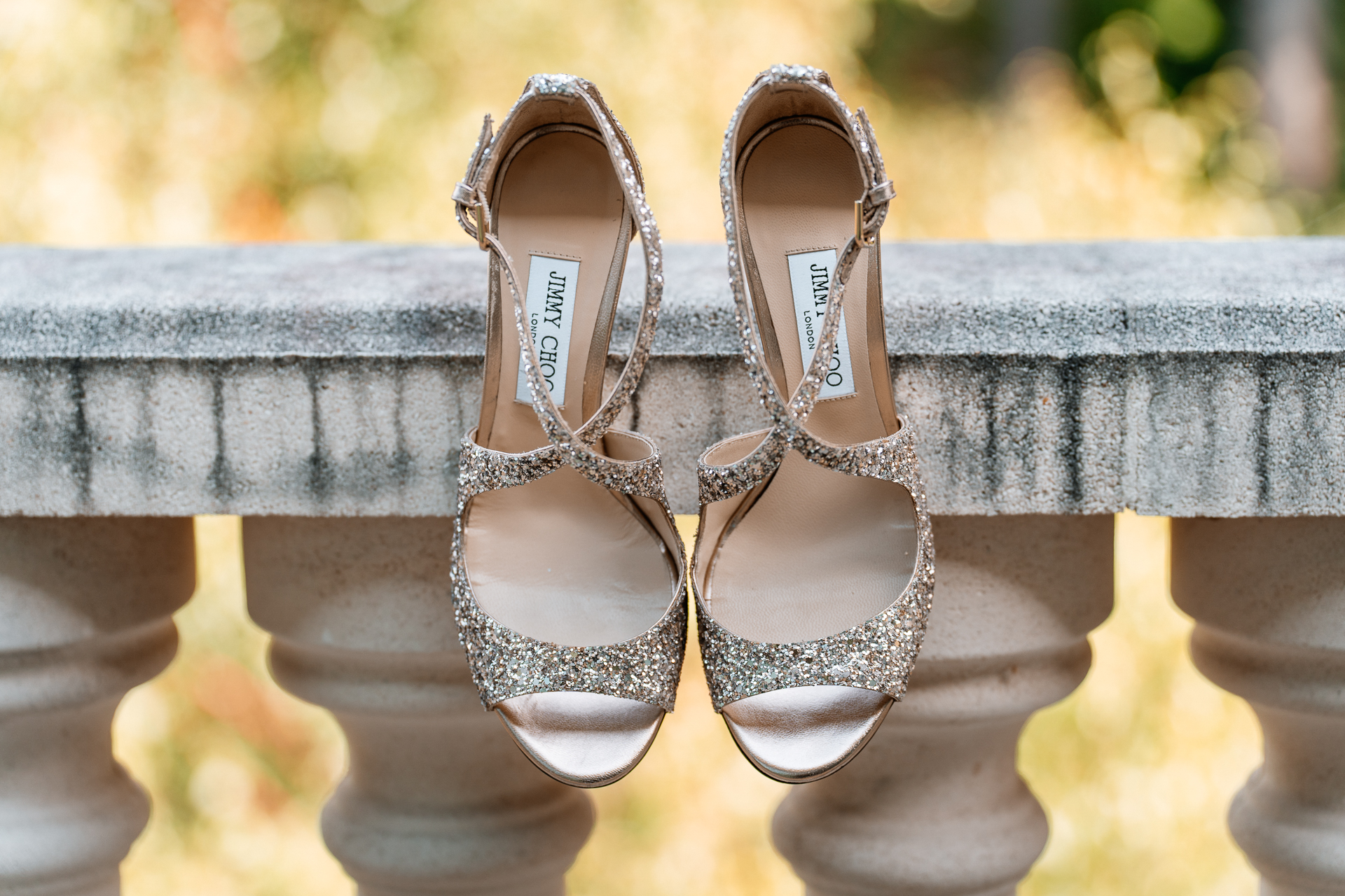 A pair of gold sandals on a wooden bench