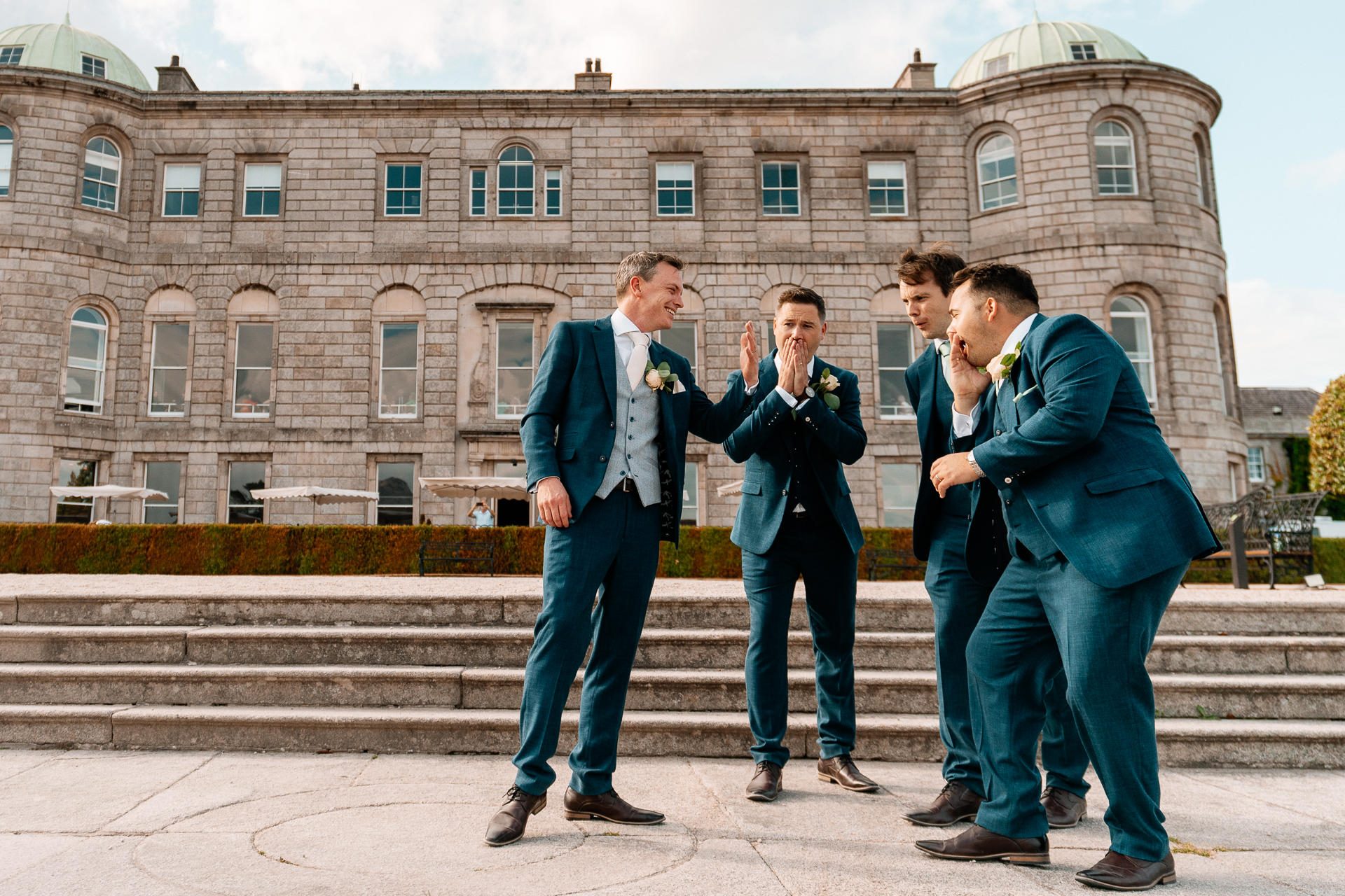 A group of men posing for a picture in front of a building