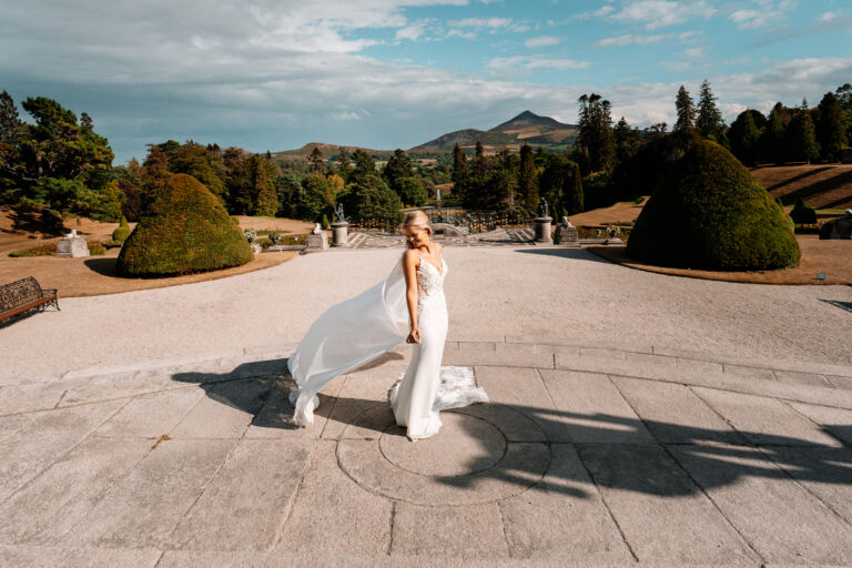 A person in a white dress holding a white sheet over the head