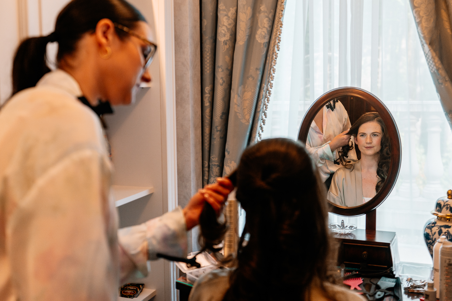 Bride getting ready at Powerscourt House, Wicklow, with her bridesmaids assisting in a luxurious suite.