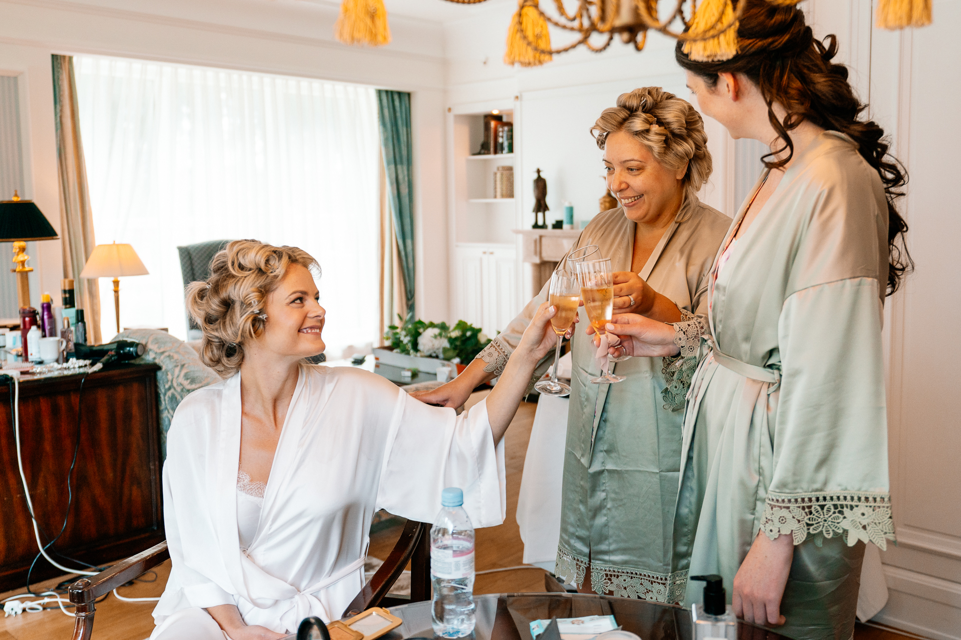 Bride getting ready at Powerscourt House, Wicklow, with her bridesmaids assisting in a luxurious suite.