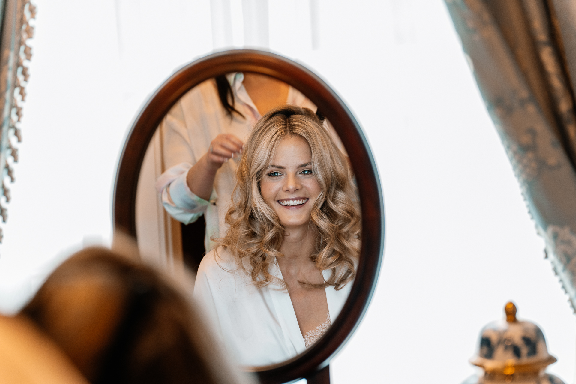 Bride getting ready at Powerscourt House, Wicklow, with her bridesmaids assisting in a luxurious suite.