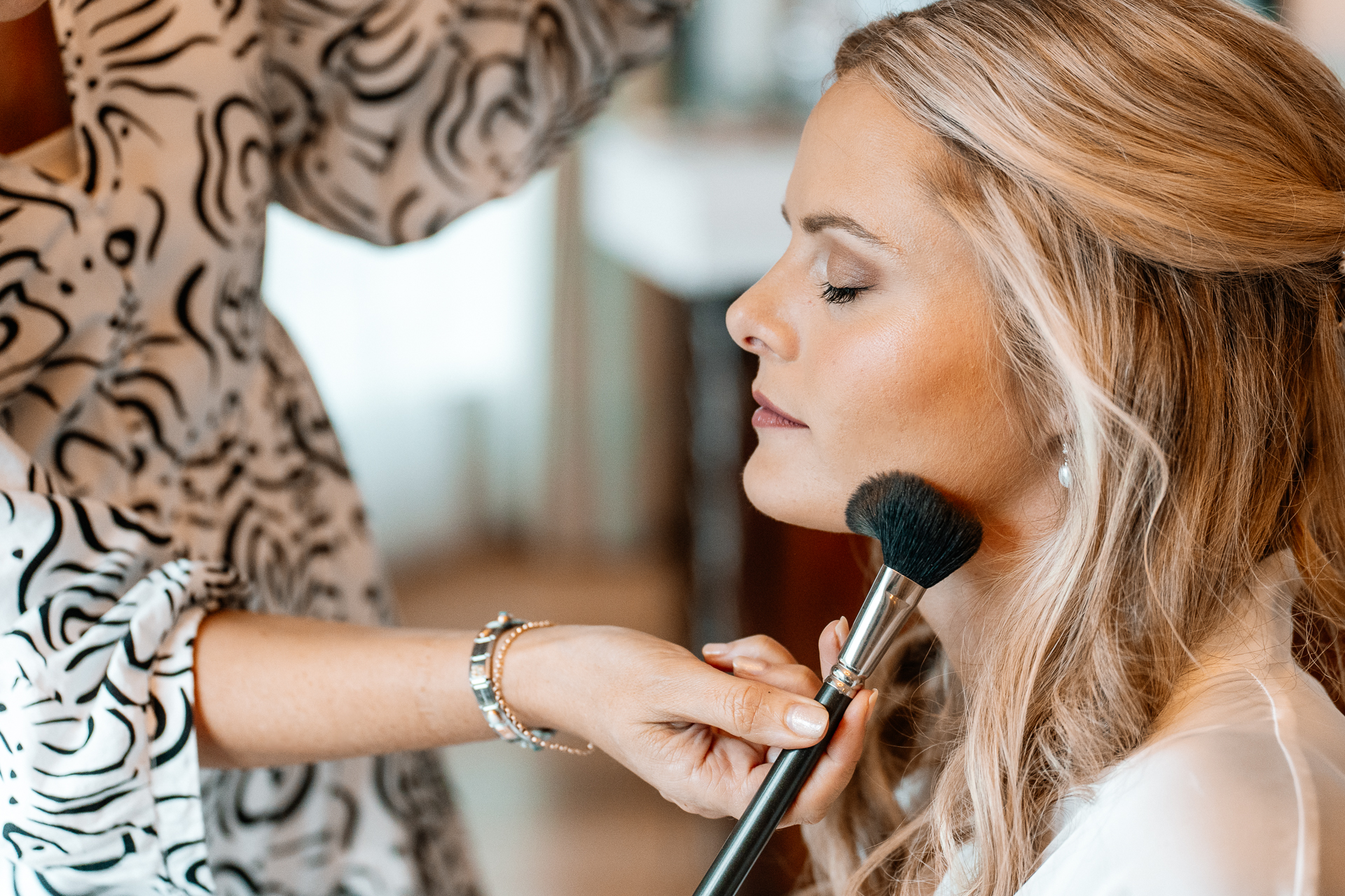 Bride getting ready at Powerscourt House, Wicklow, with her bridesmaids assisting in a luxurious suite.