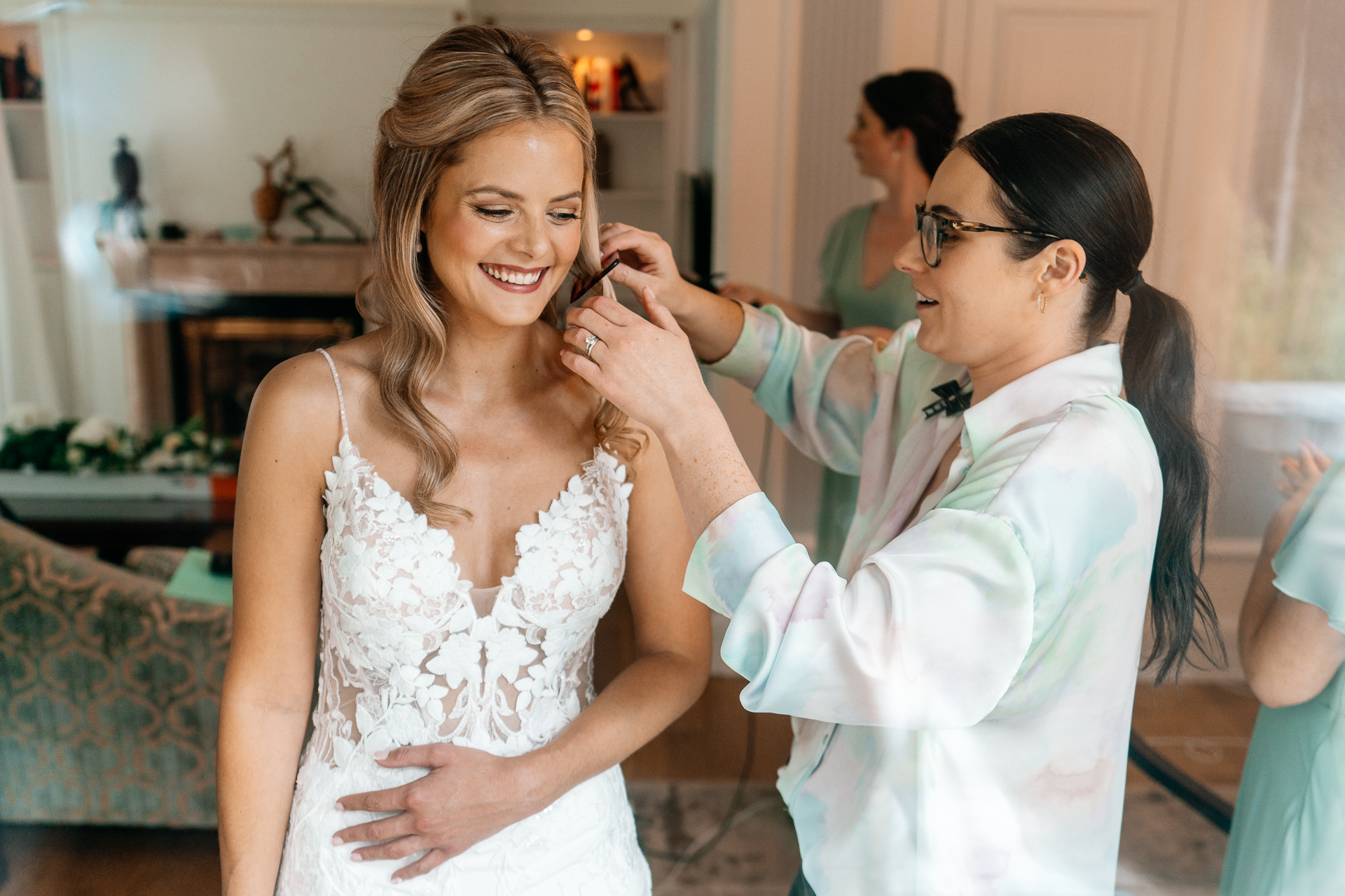 Bride getting ready at Powerscourt House, Wicklow, with her bridesmaids assisting in a luxurious suite.