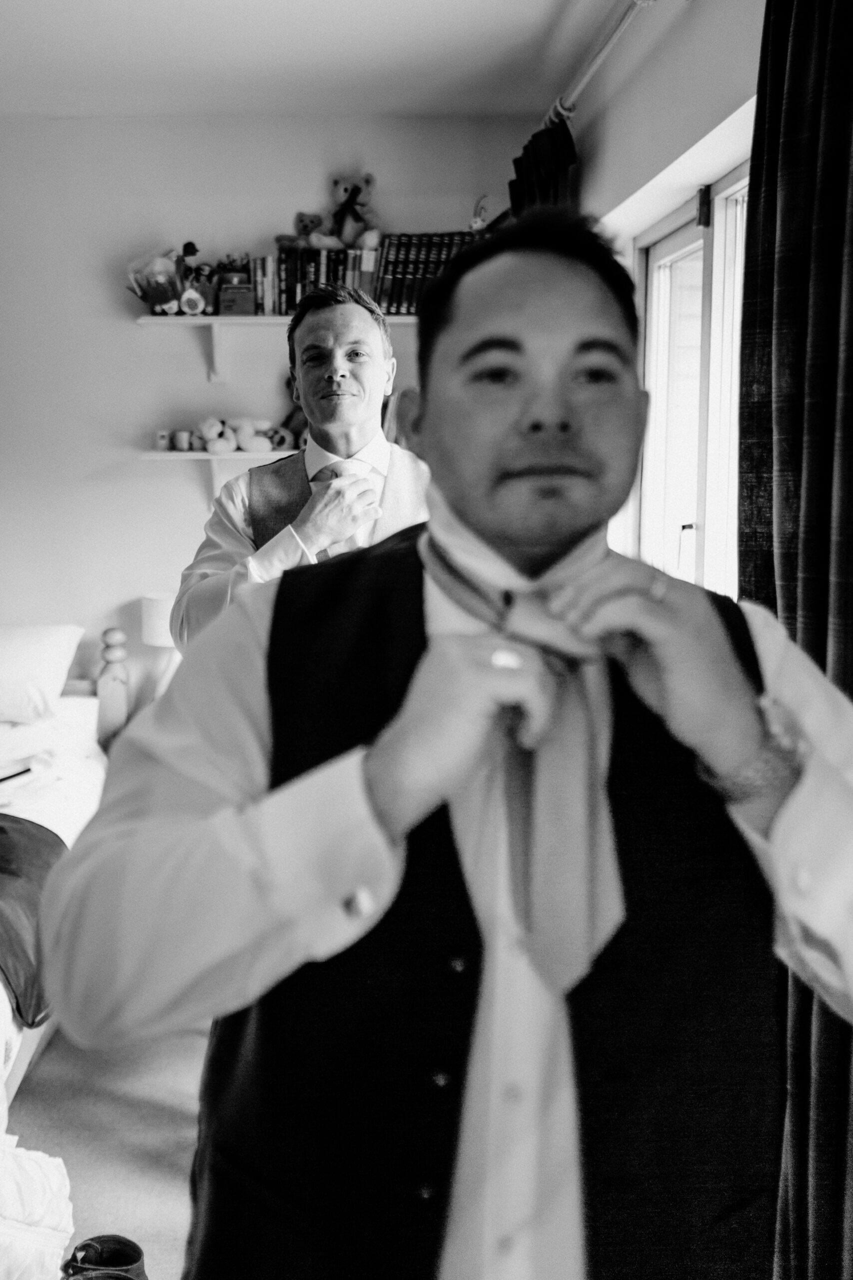 Groom adjusting his tie in the grand interiors of Powerscourt House in Wicklow.