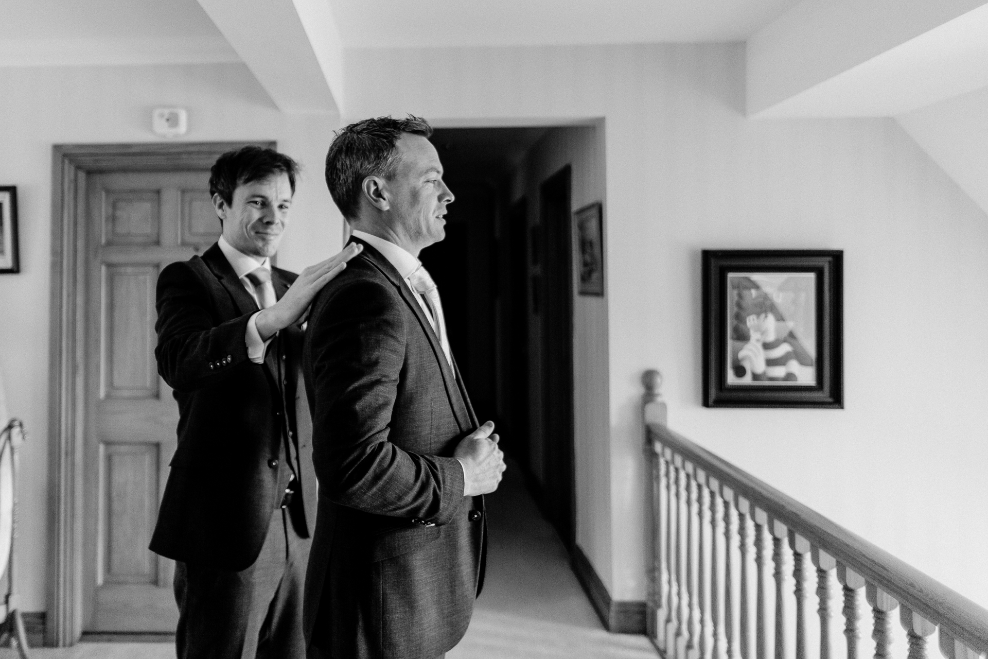 Groom adjusting his tie in the grand interiors of Powerscourt House in Wicklow.