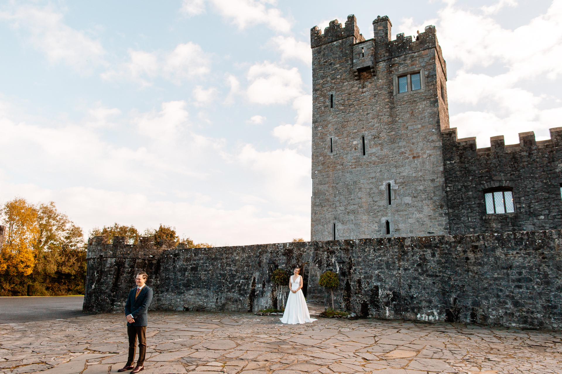 A man and woman in front of a castle