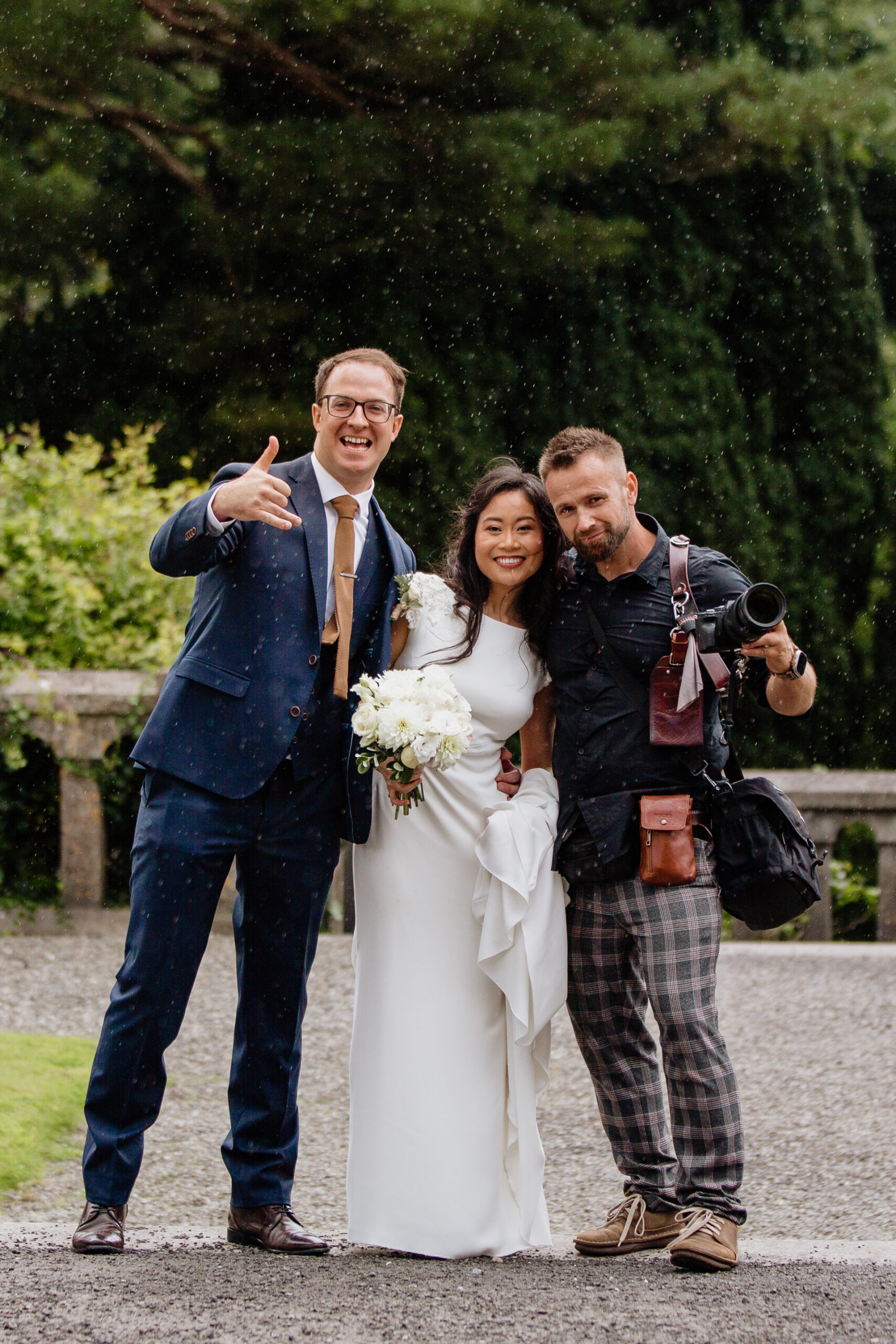 Wojciech Koza, an award-winning Sligo Wedding Photographer, posing with a newlywed couple at Belleek Castle after a beautiful wedding ceremony.