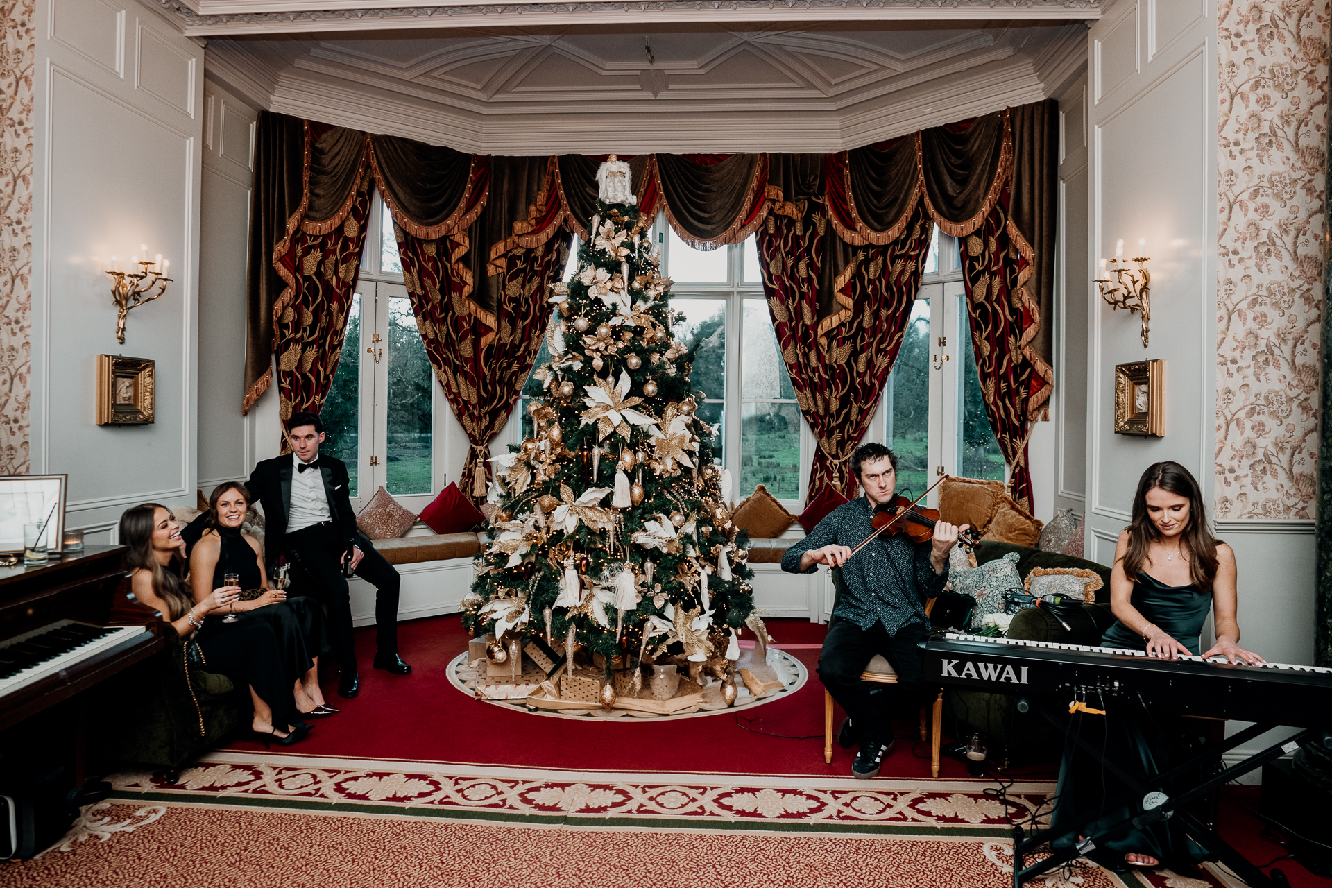 A group of people sitting in a room with a christmas tree