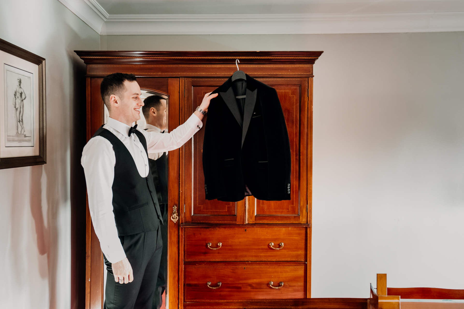 A person holding a coat on a door