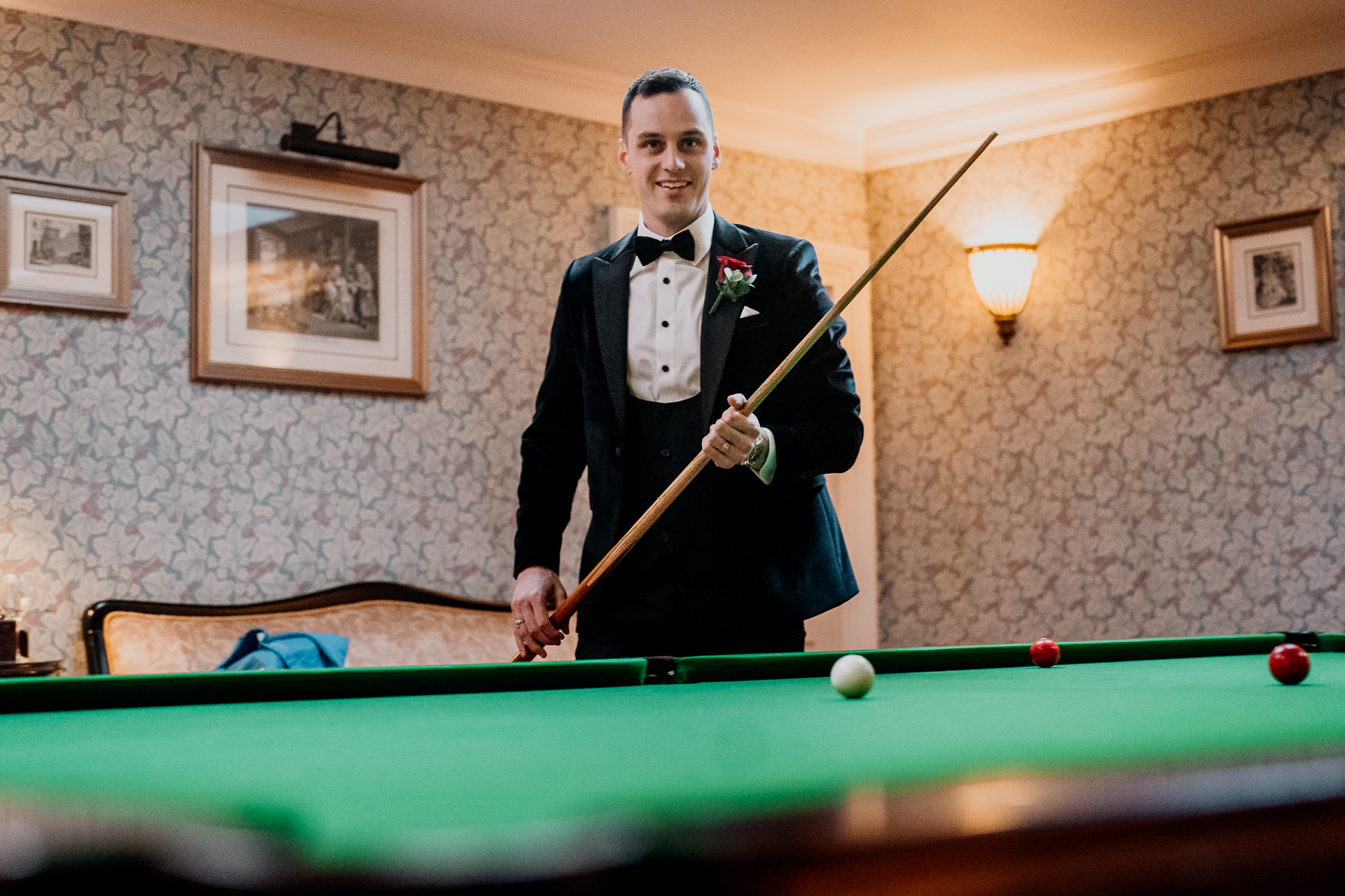 A man in a suit playing pool