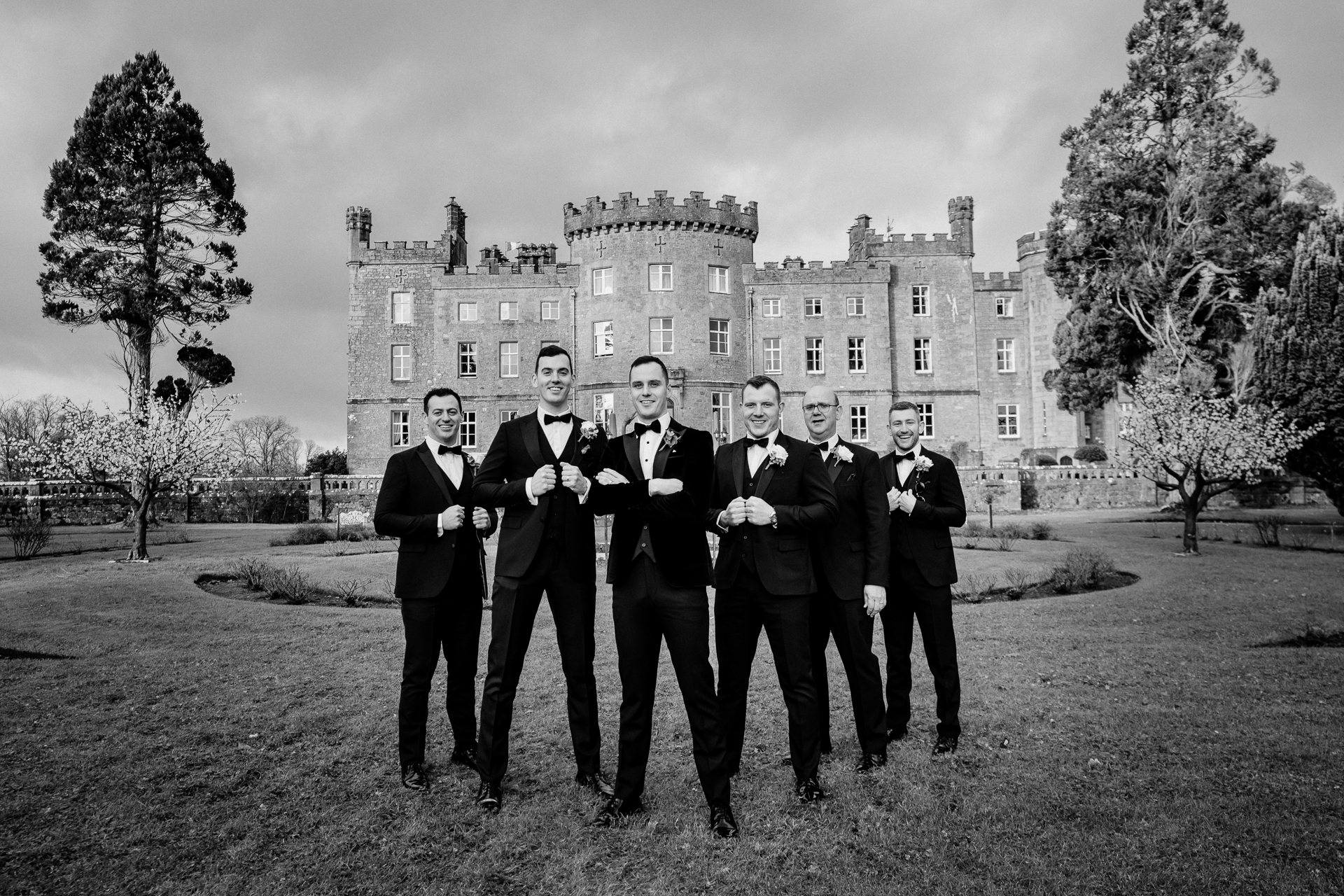 A group of men in suits standing in front of a large building