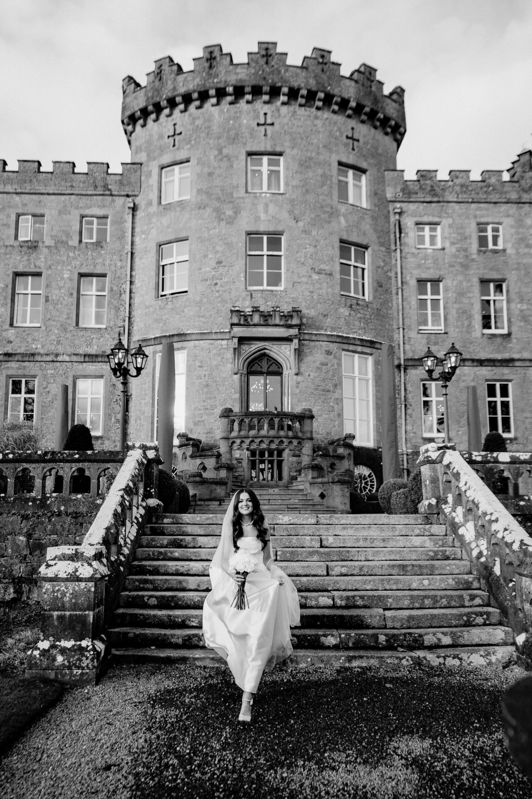 A person in a white dress standing on stairs in front of a building