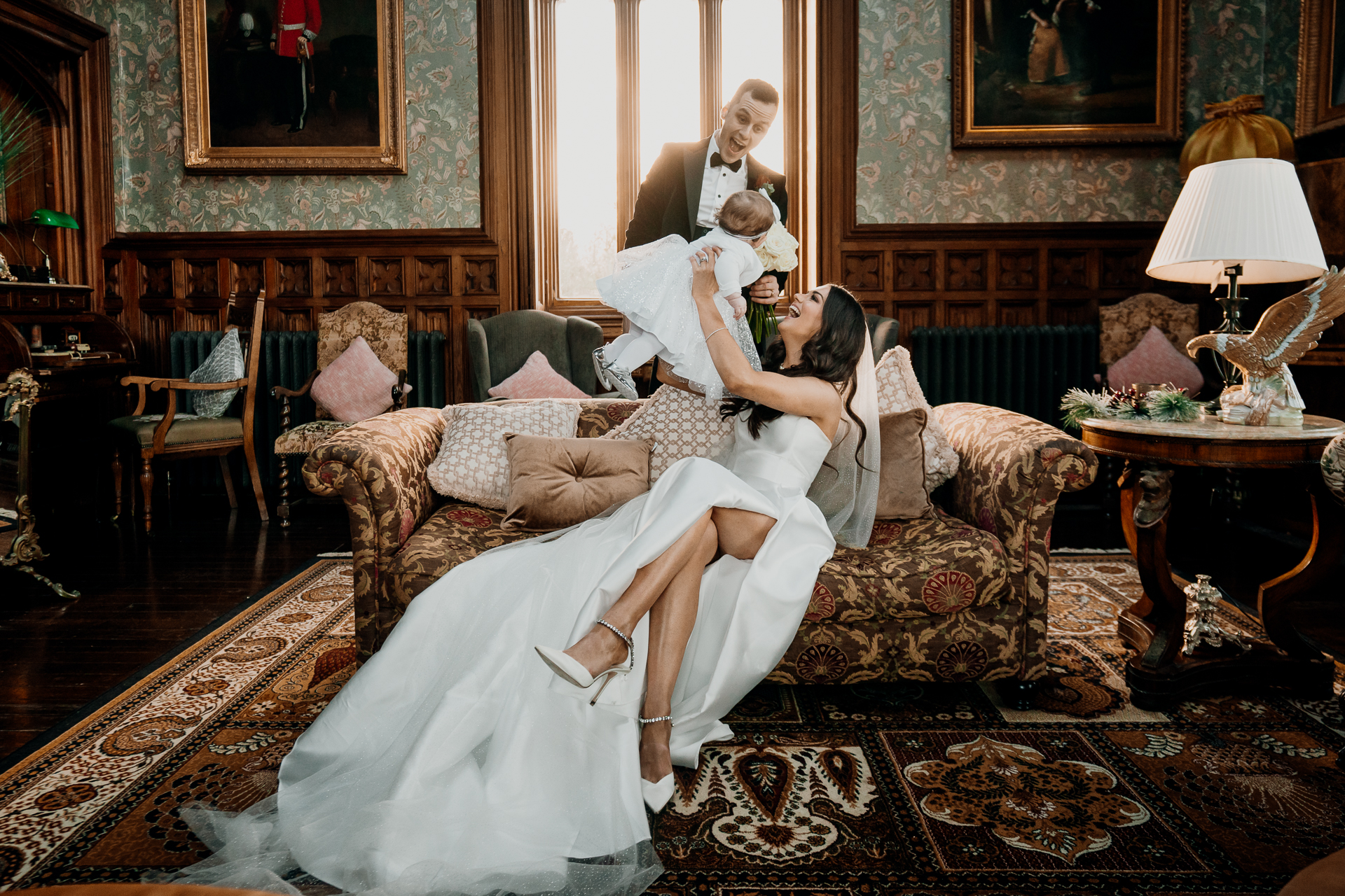 A woman in a white dress sitting on a couch with a man in a white robe and a