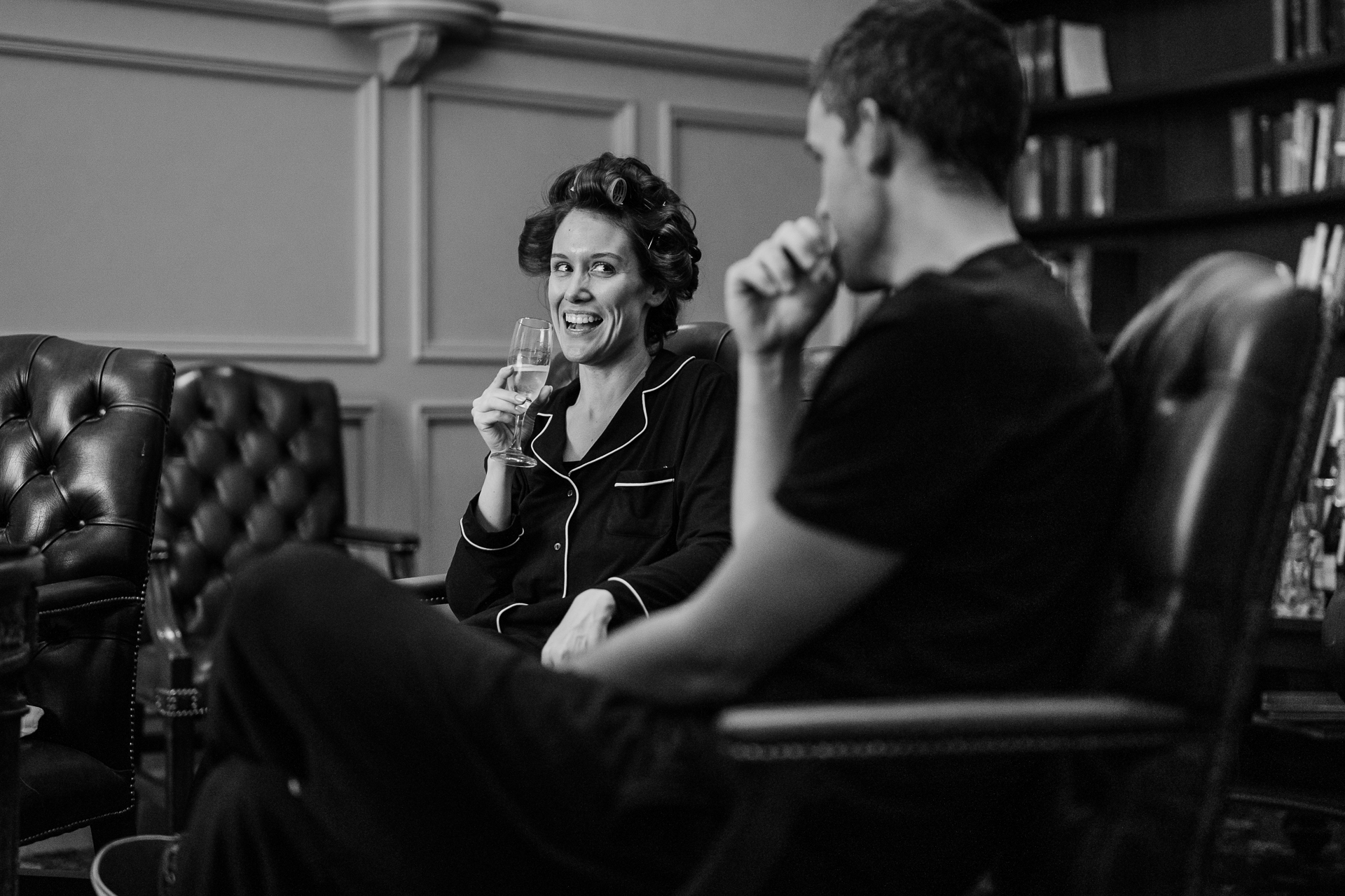 A man and a woman sitting in chairs and holding wine glasses