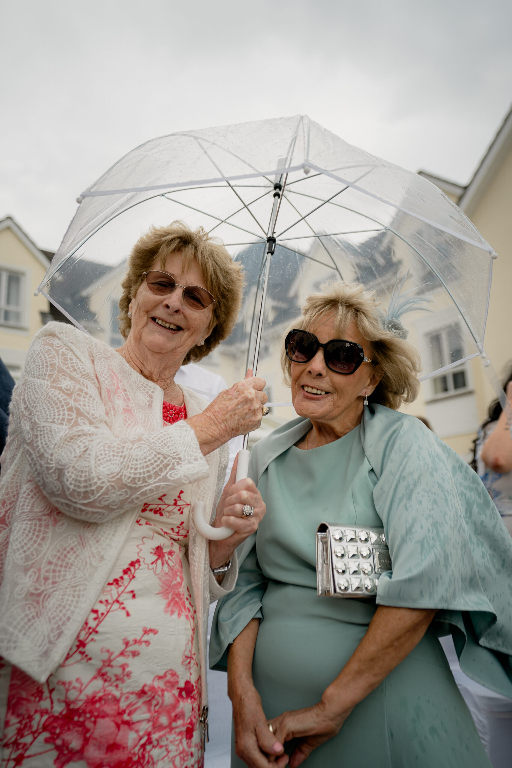 A couple of women holding an umbrella