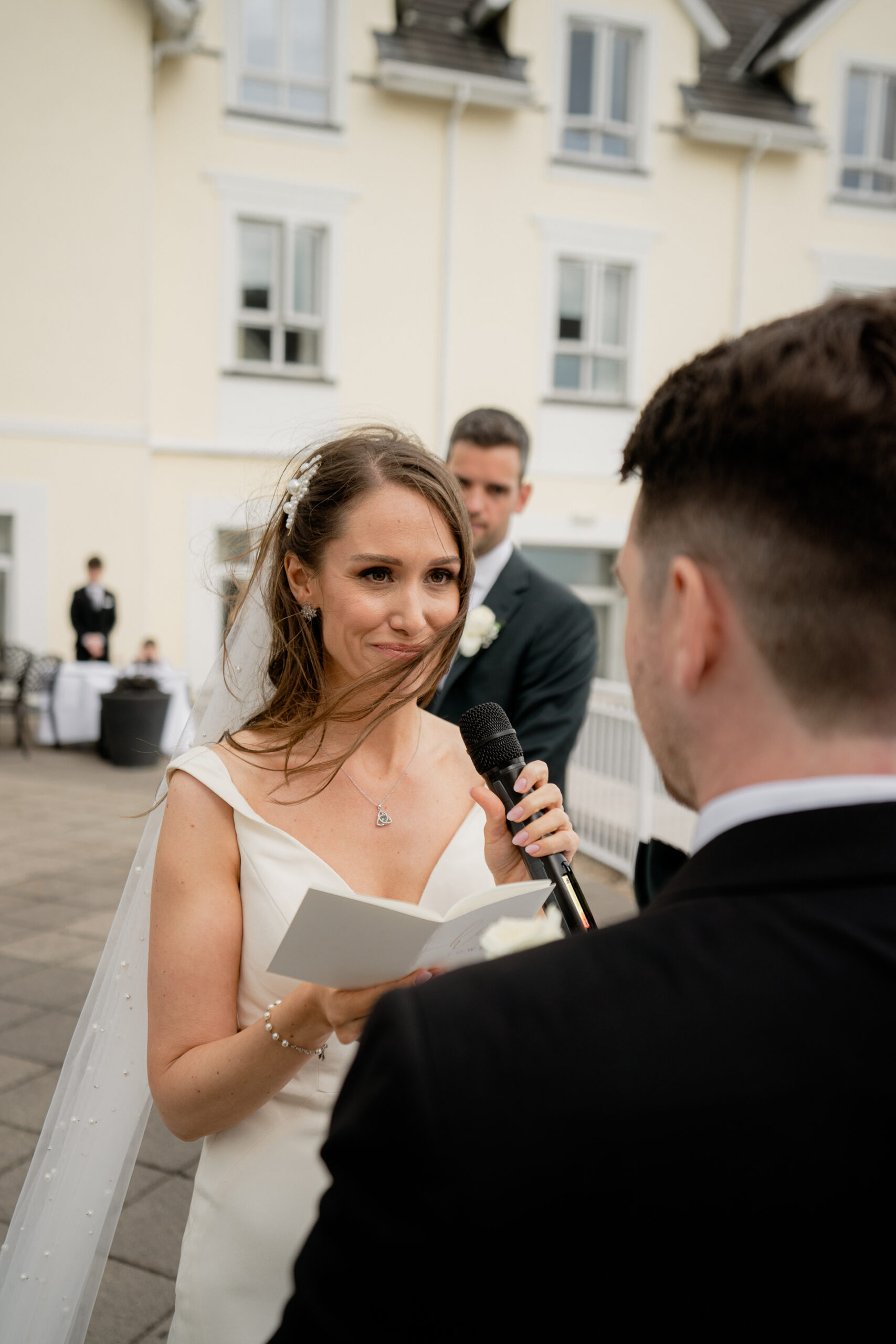 A woman in a white dress holding a microphone and a man in a suit