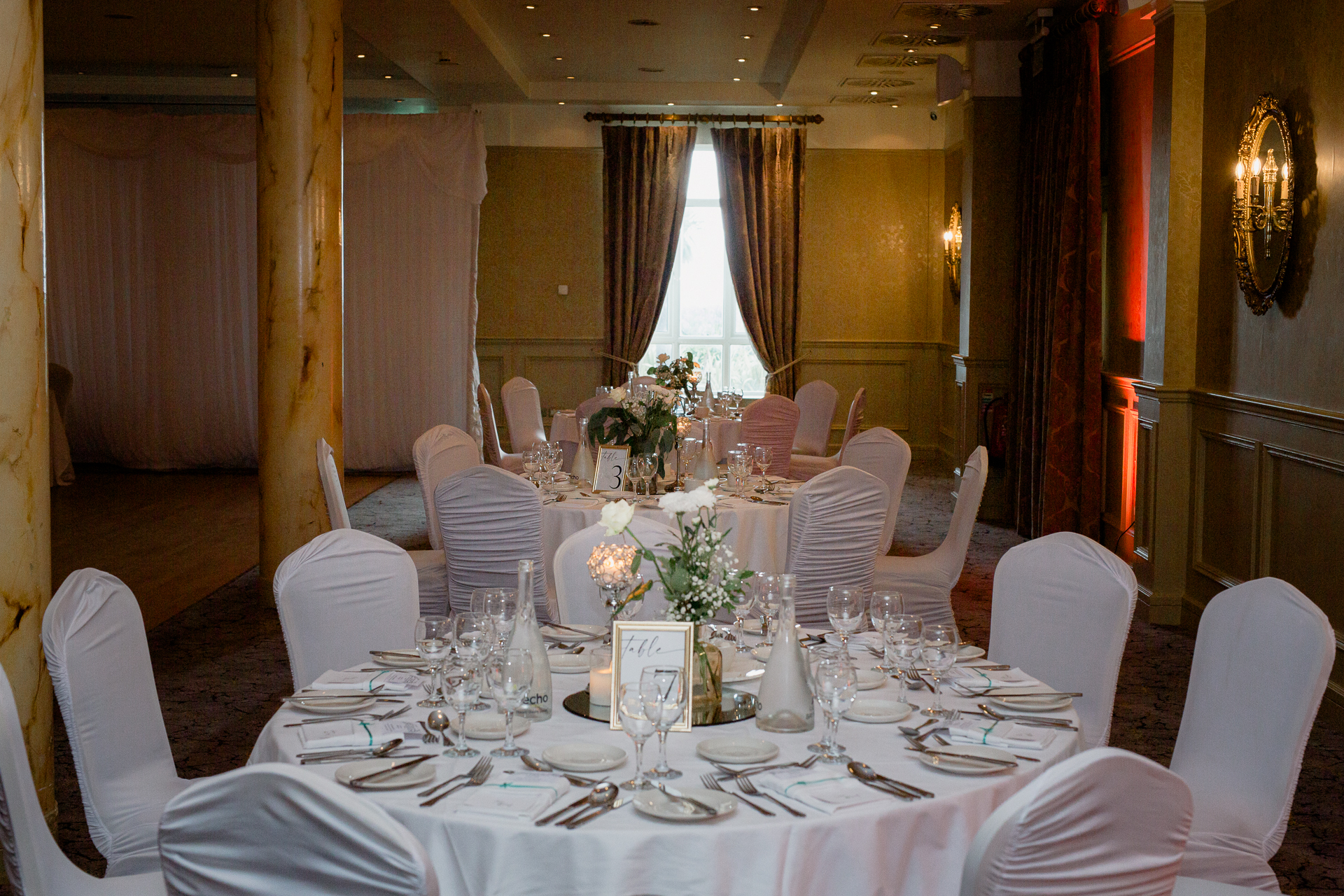 A dining room with a large table set for a formal dinner