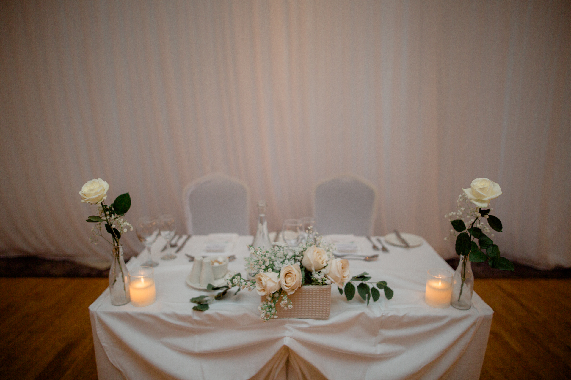 A table with white flowers and candles