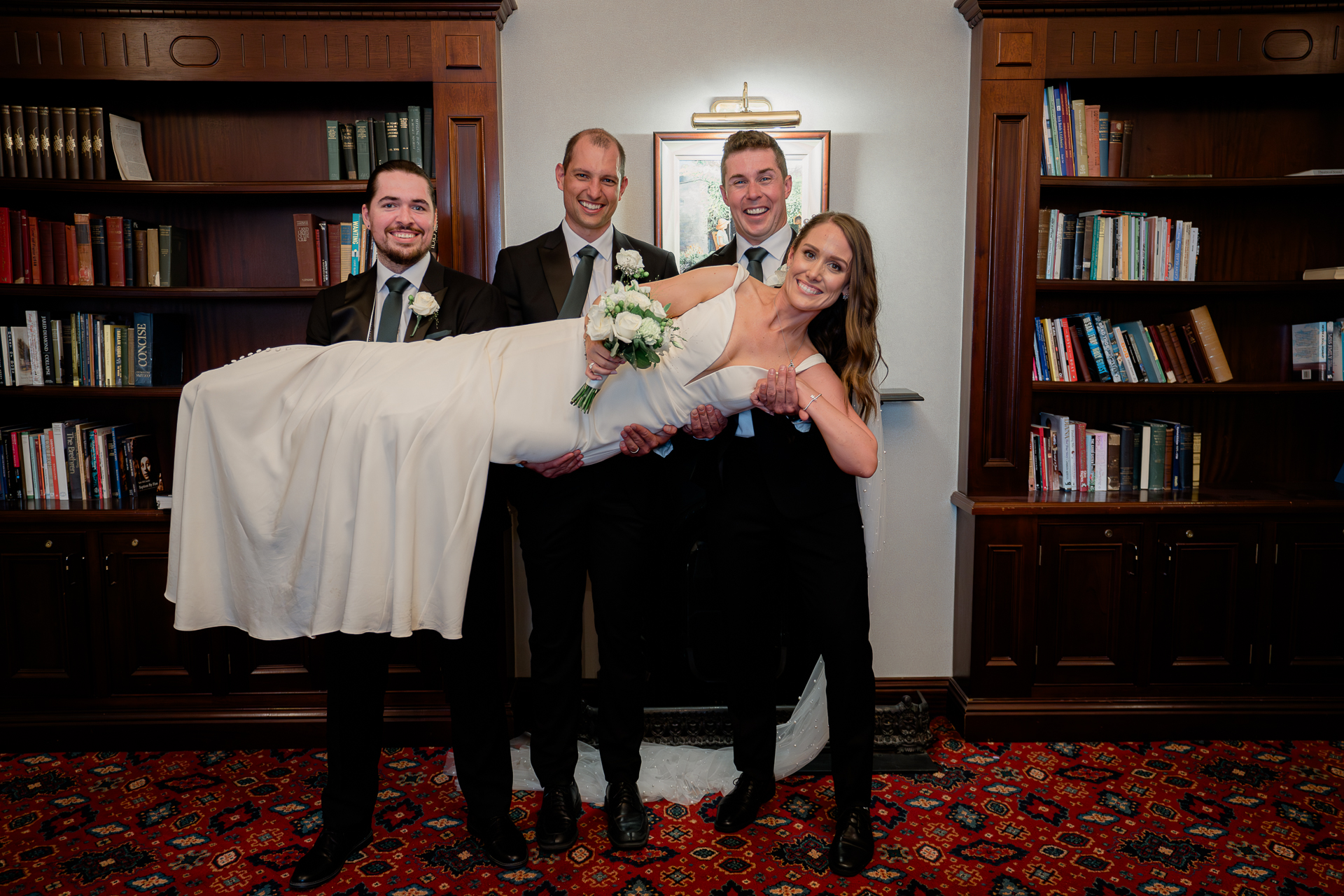 A man and woman holding a man in a tuxedo