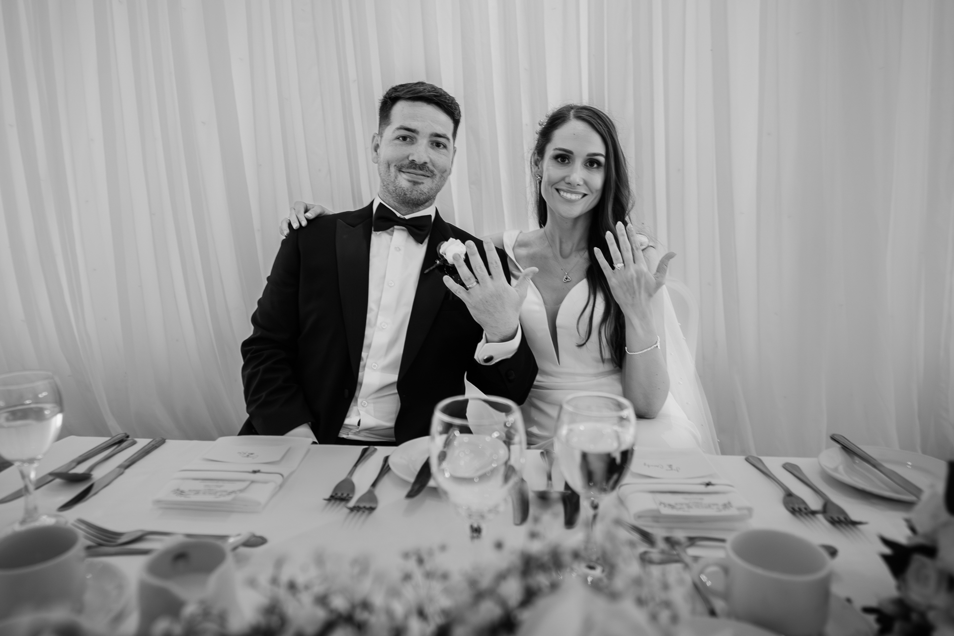 A man and woman sitting at a table with food and drinks