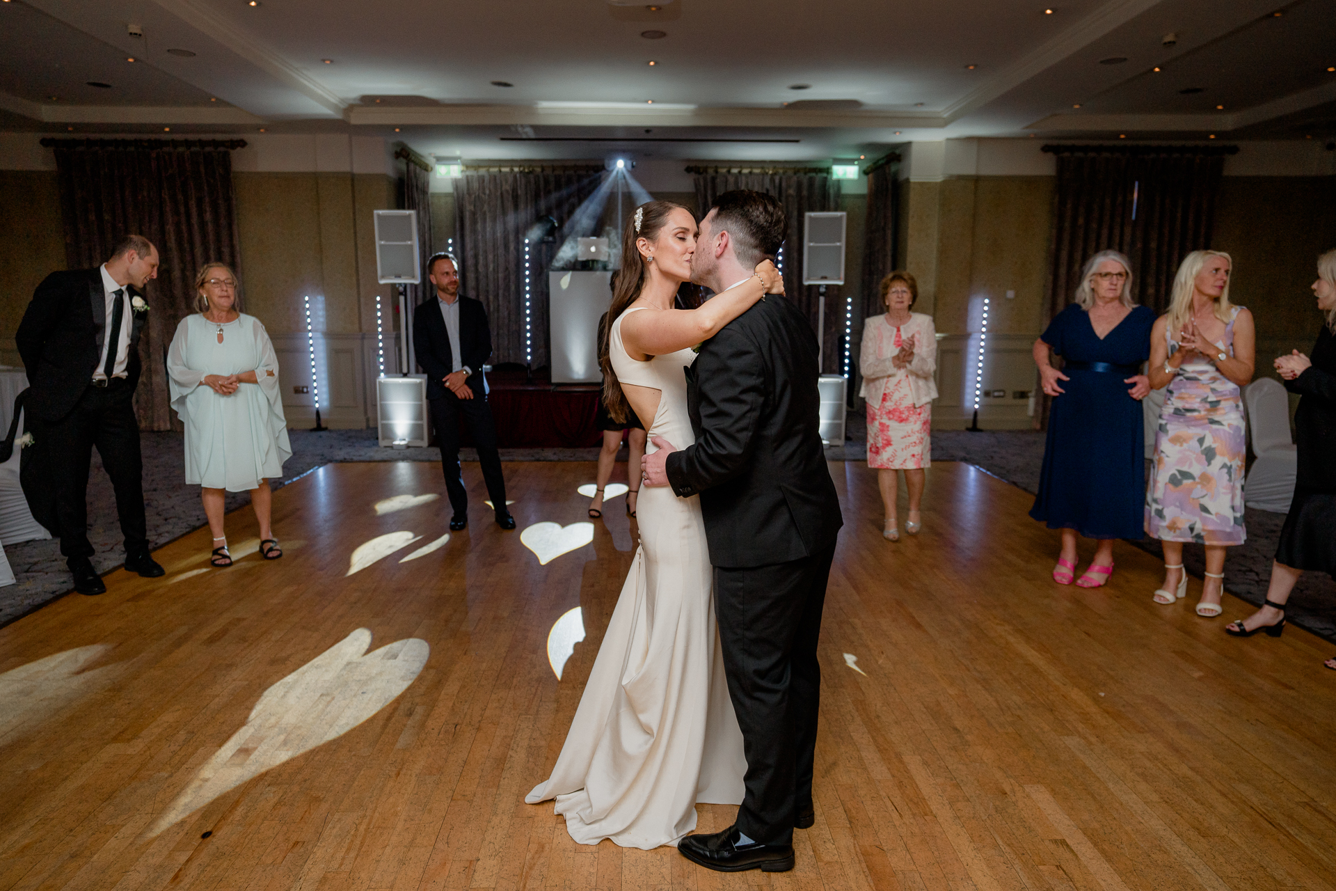 A man and woman dancing in a room with other people