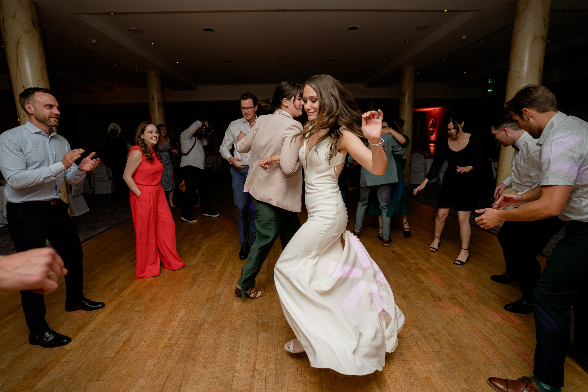 A person in a white dress dancing with a group of people