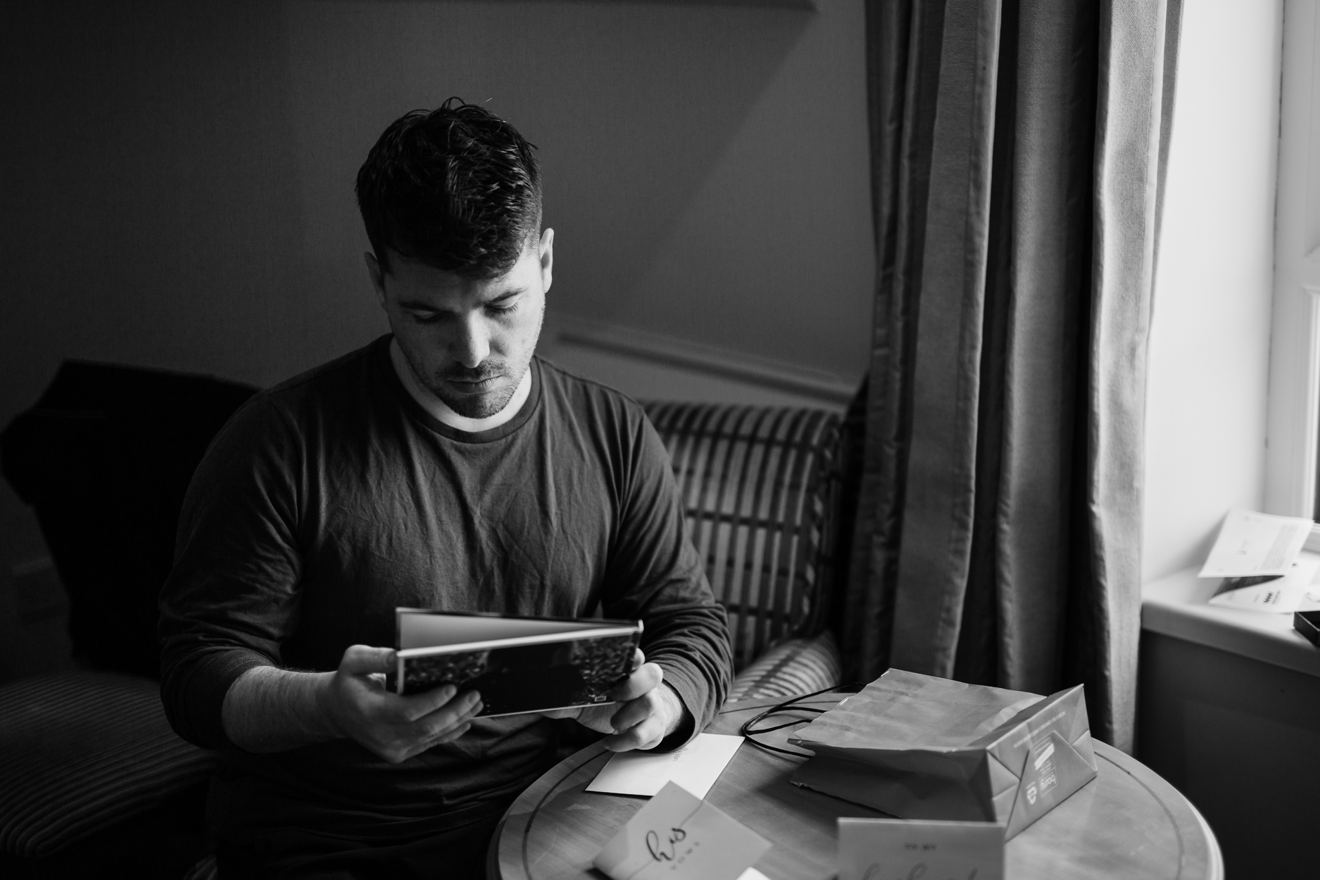 A man sitting at a table looking at a book