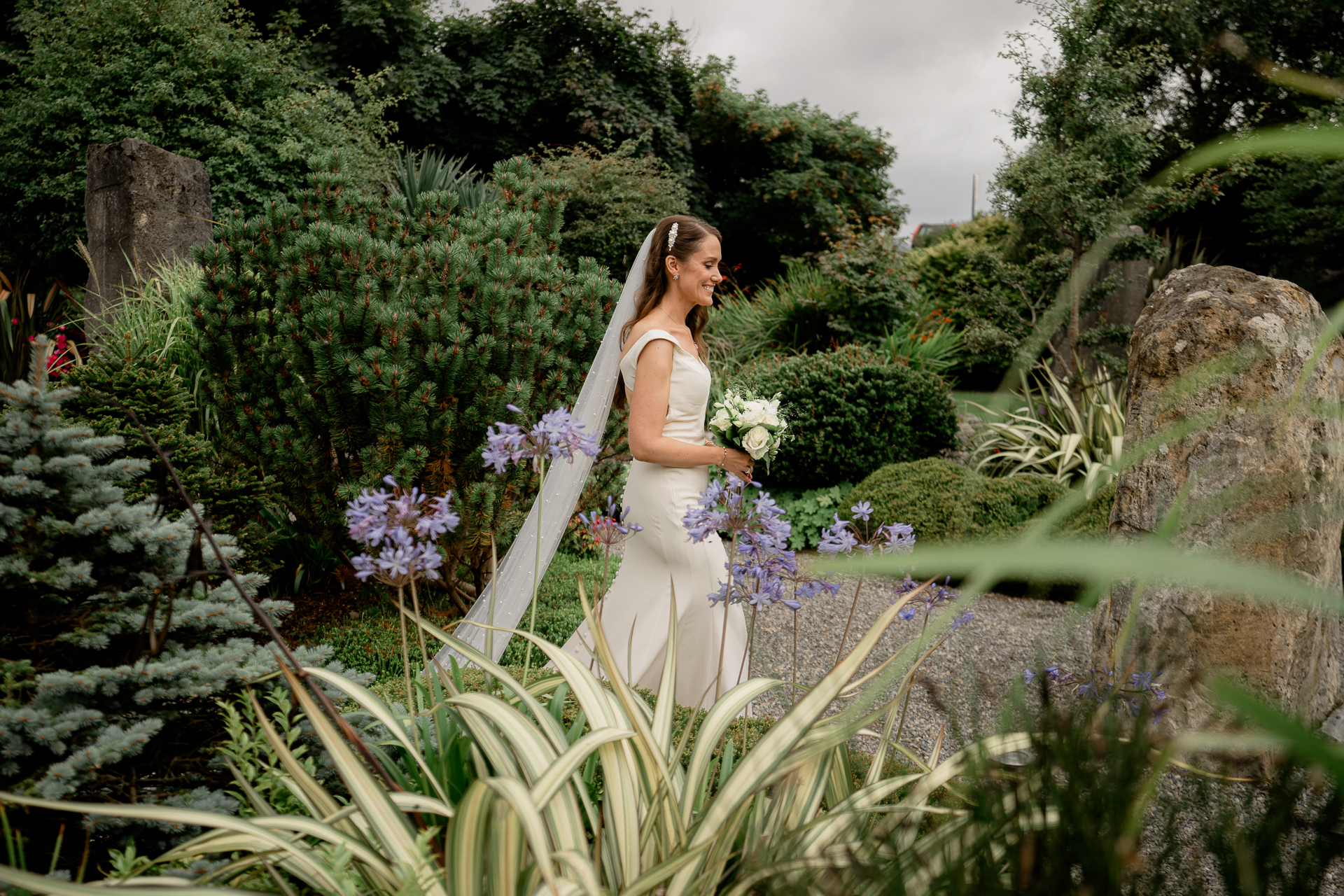 A person in a white dress standing in a garden