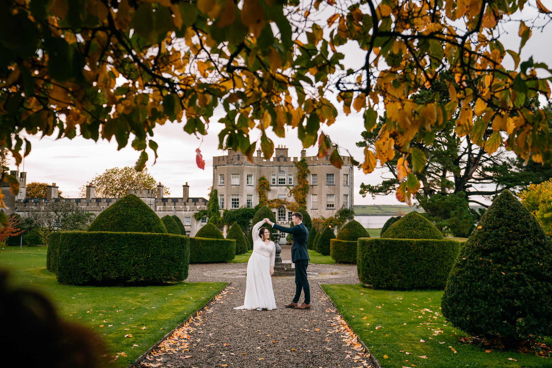 A man and woman in wedding attire standing in a garden