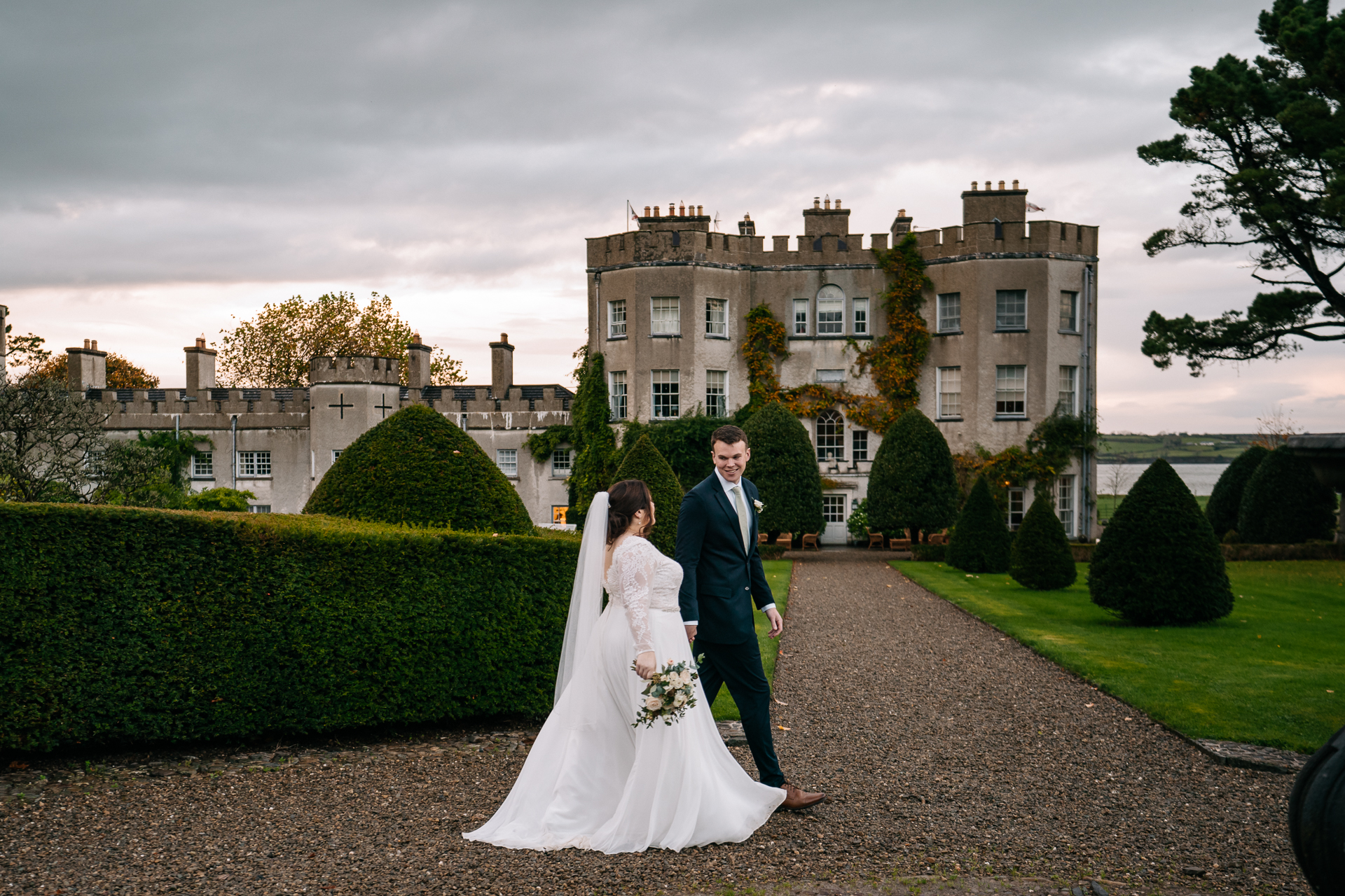 A man and woman in wedding attire standing in front of a large building