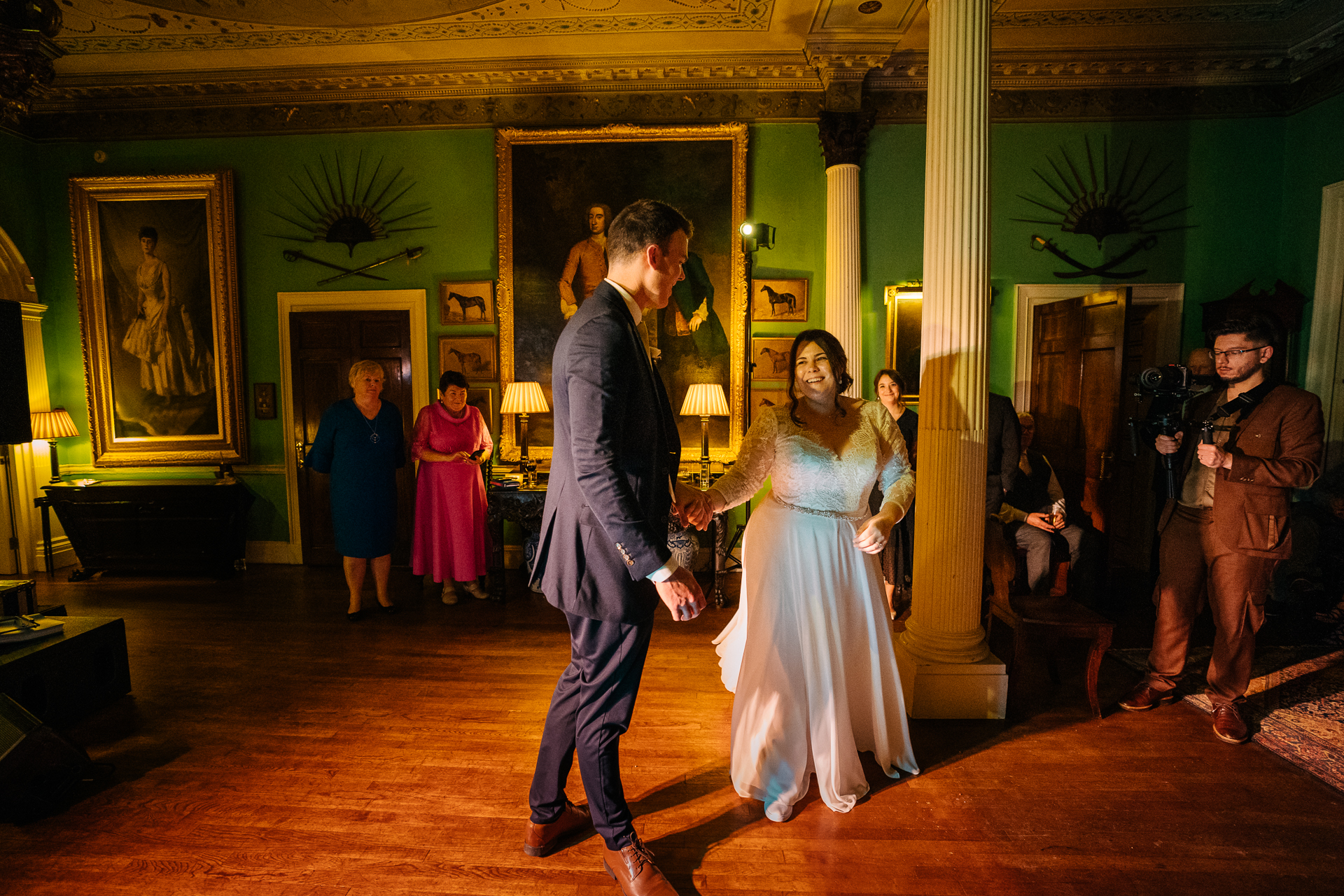 A man and woman walking down a hall with a man in a suit