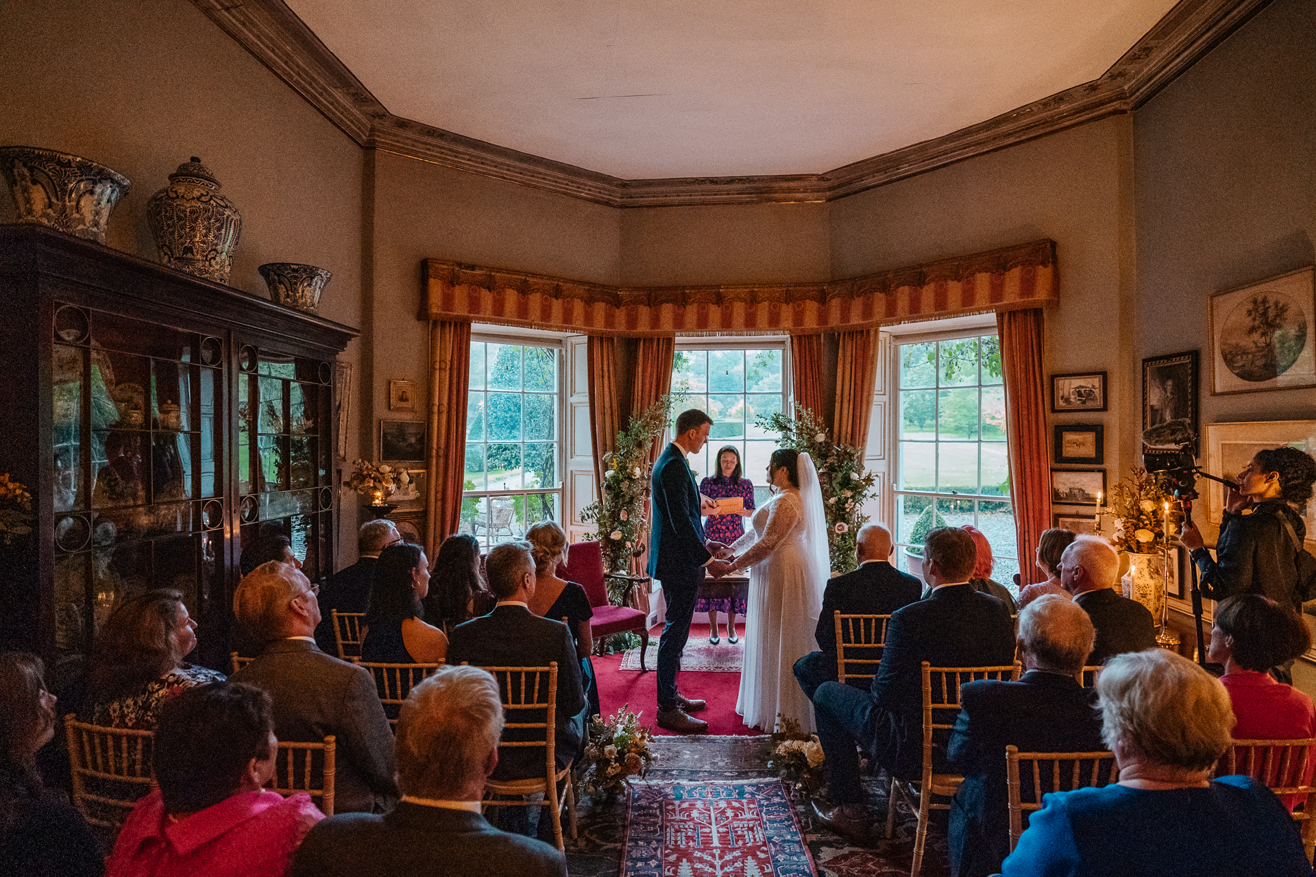 A bride and groom dancing in a room with a crowd watching