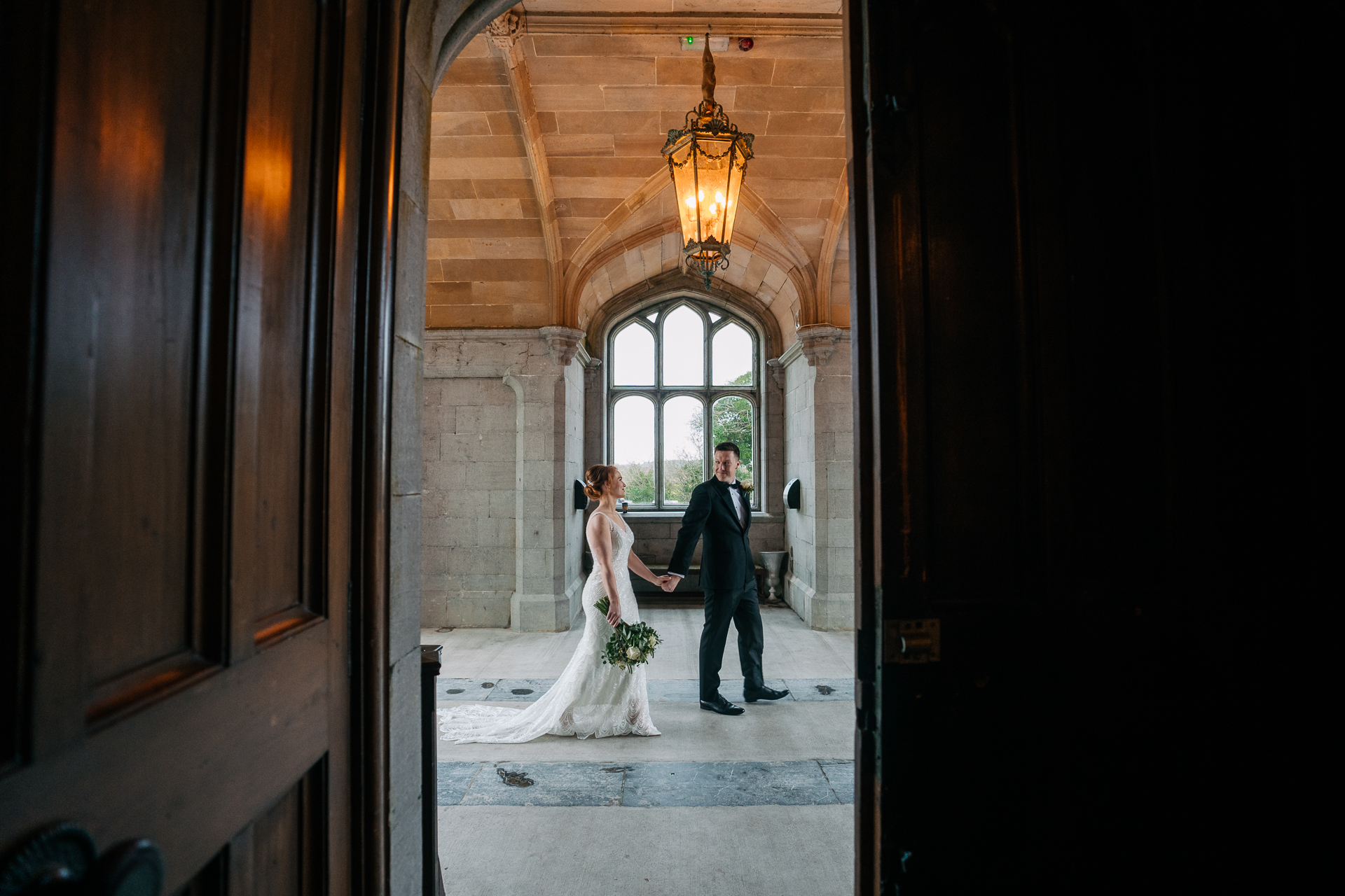 A bride and groom walking down a hall way