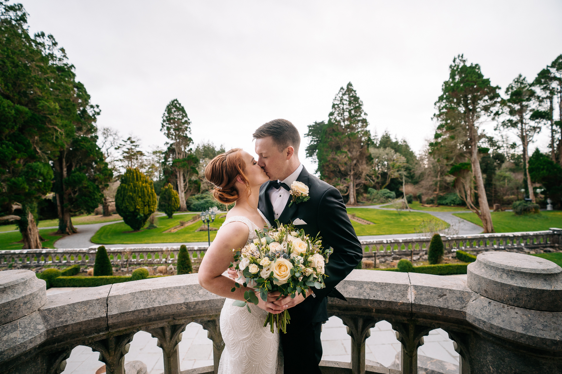 A man and woman kissing on a bridge