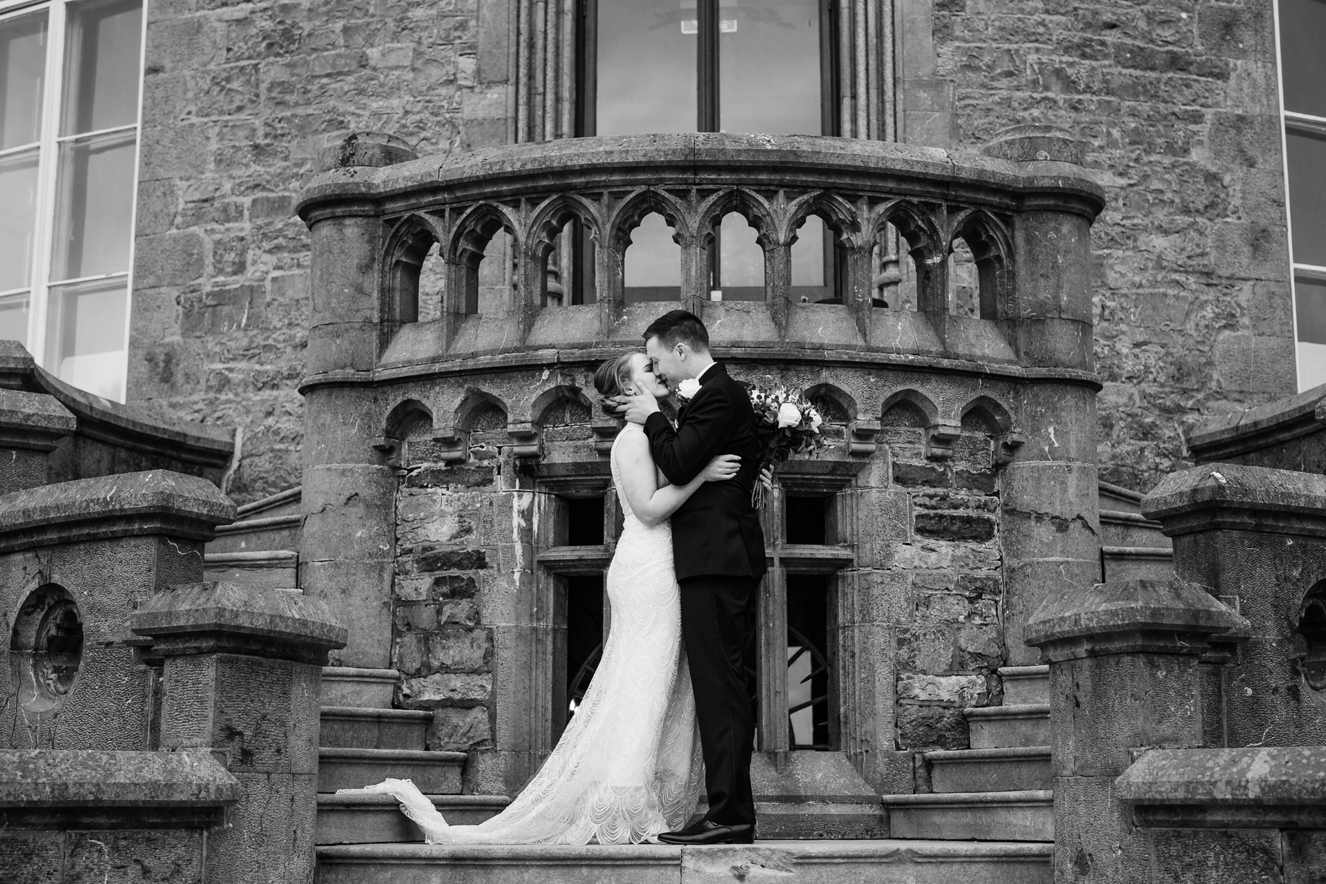 A man and woman kissing in front of a building