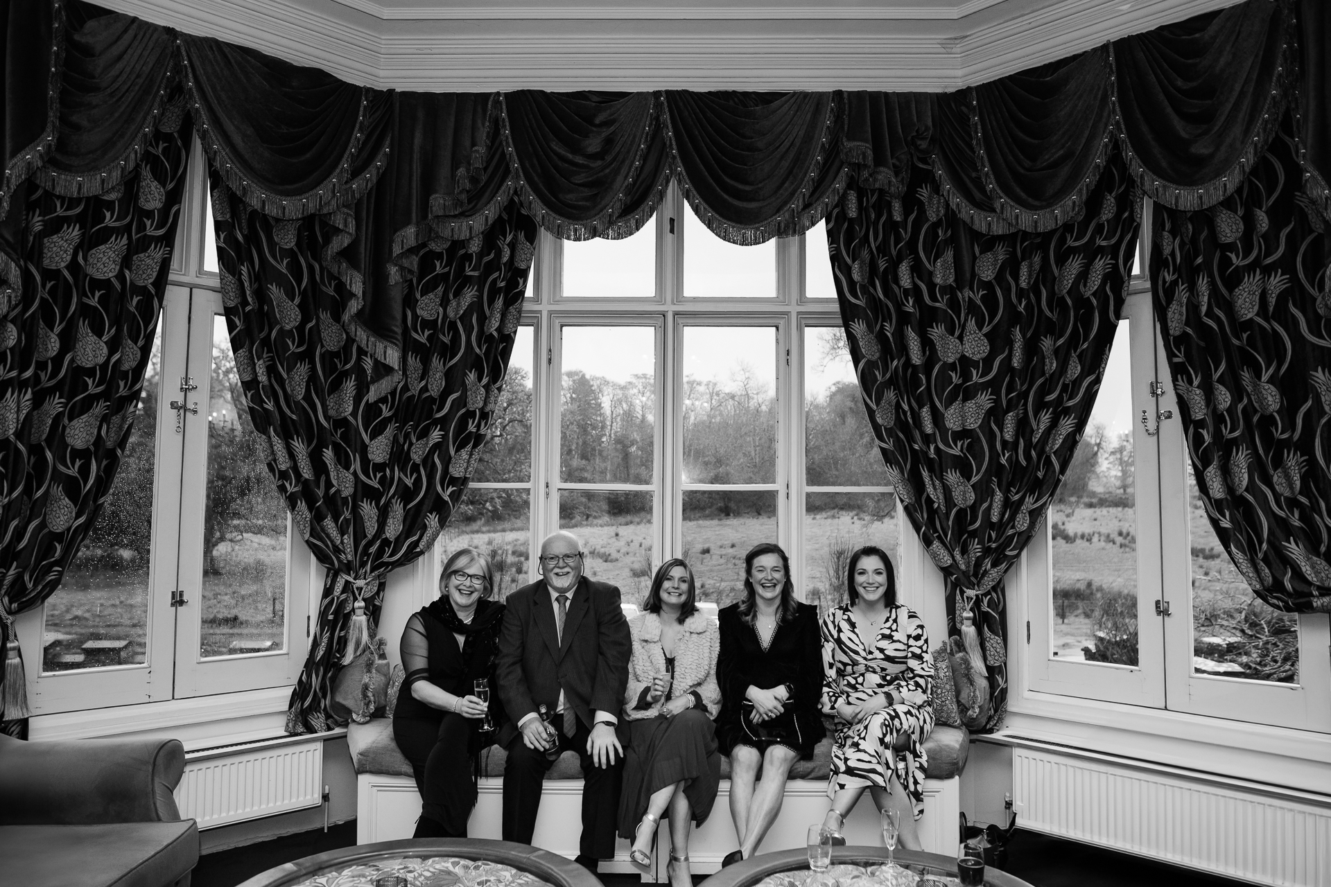 A group of people sitting on a couch in front of a window