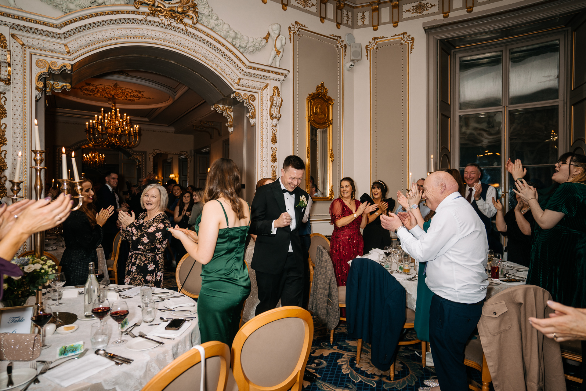 A group of people dancing in a room with tables and chairs