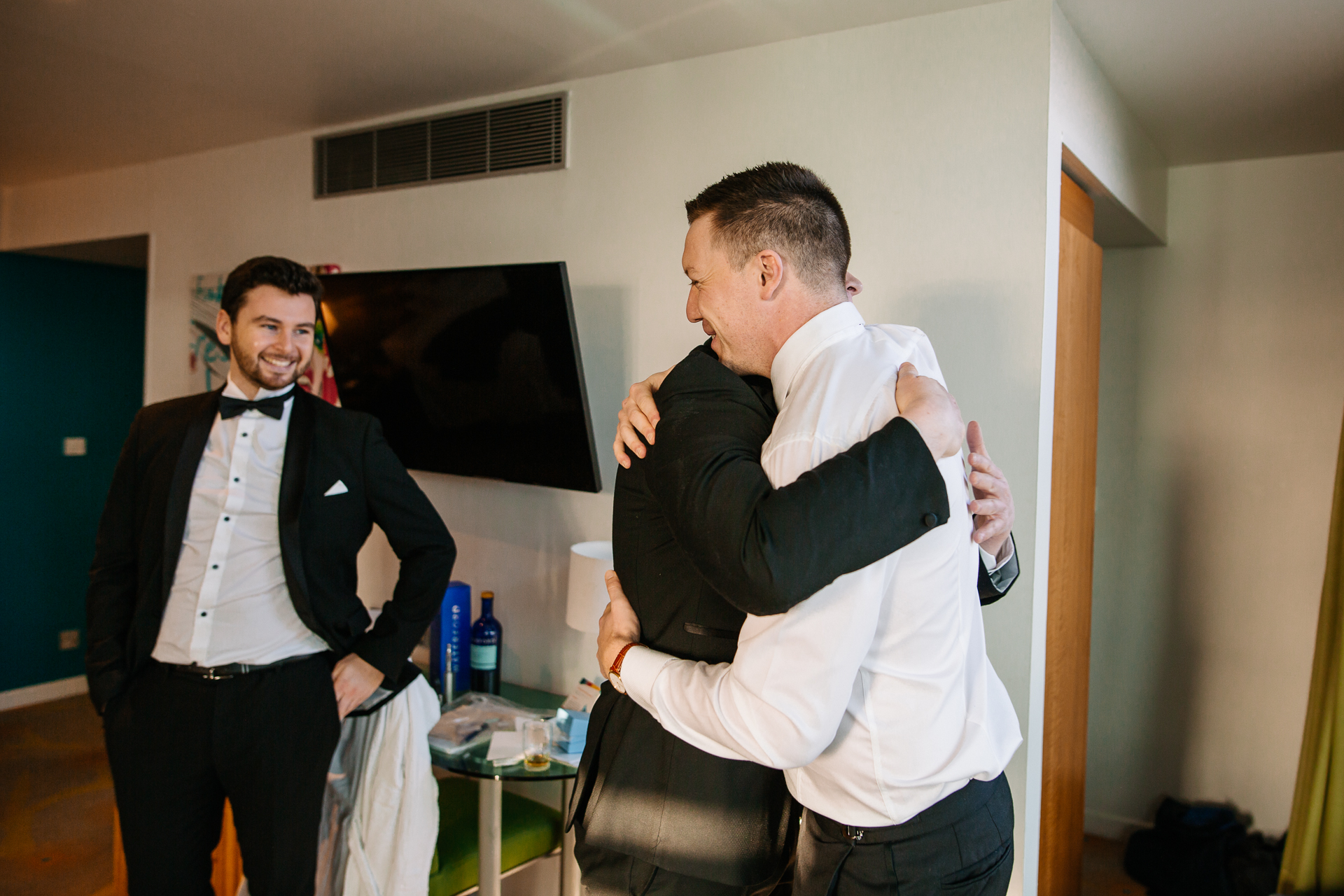 A man in a tuxedo pointing at another man in a suit