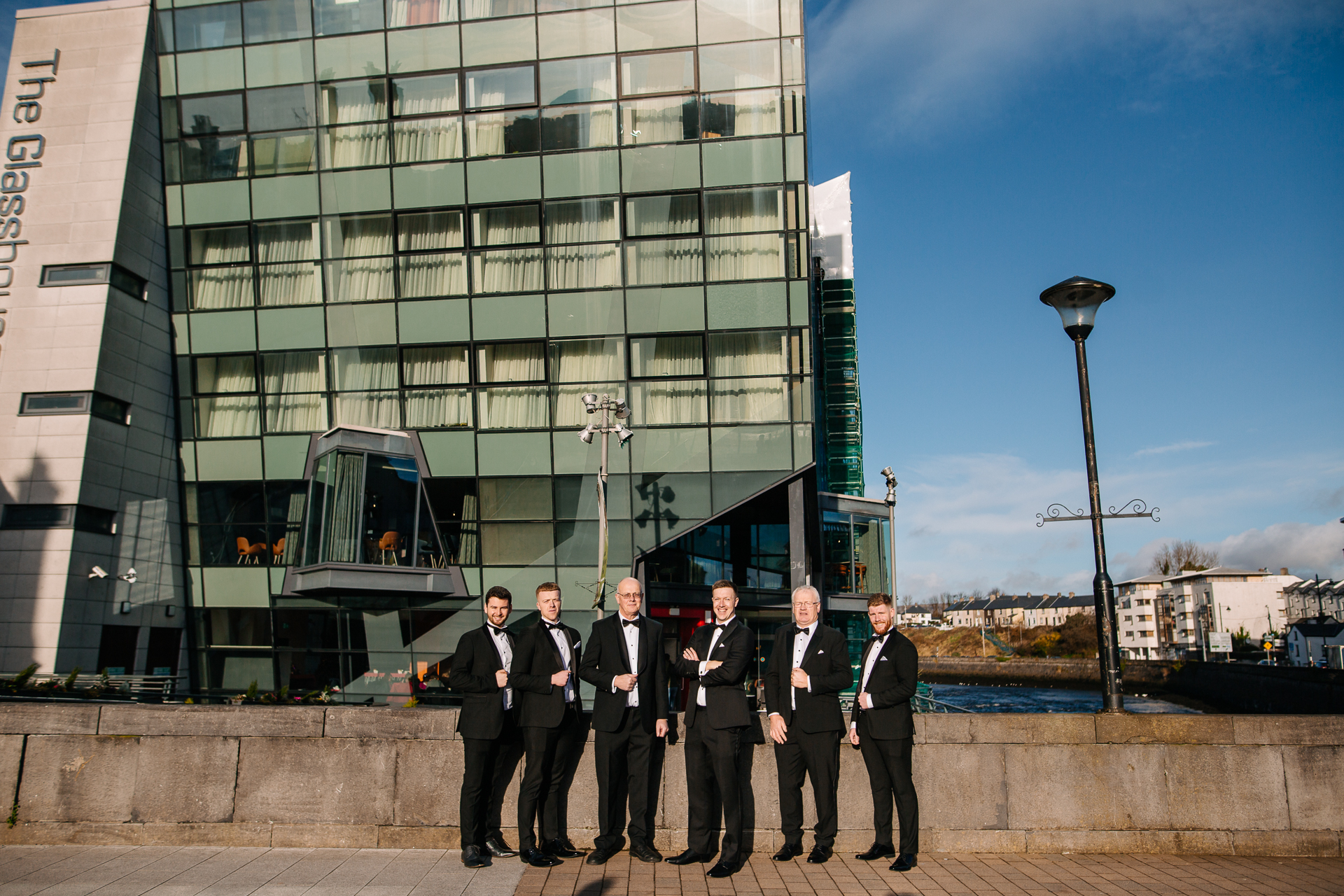 A group of men in suits standing in front of a building