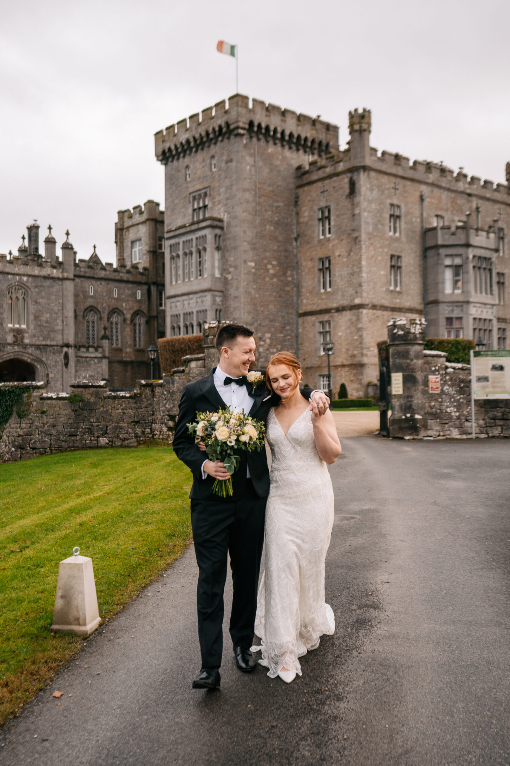 A man and woman posing in front of a castle